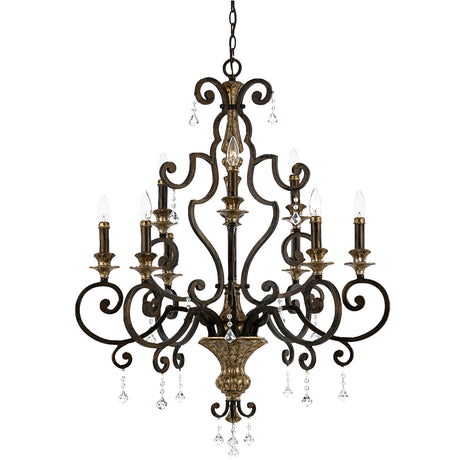 The Marquette 9 Light Chandelier in bronze boasts a dark metal frame embellished with intricate scrollwork and showcases six candle-style lights accompanied by hanging crystal drops, exuding an elegant charm.