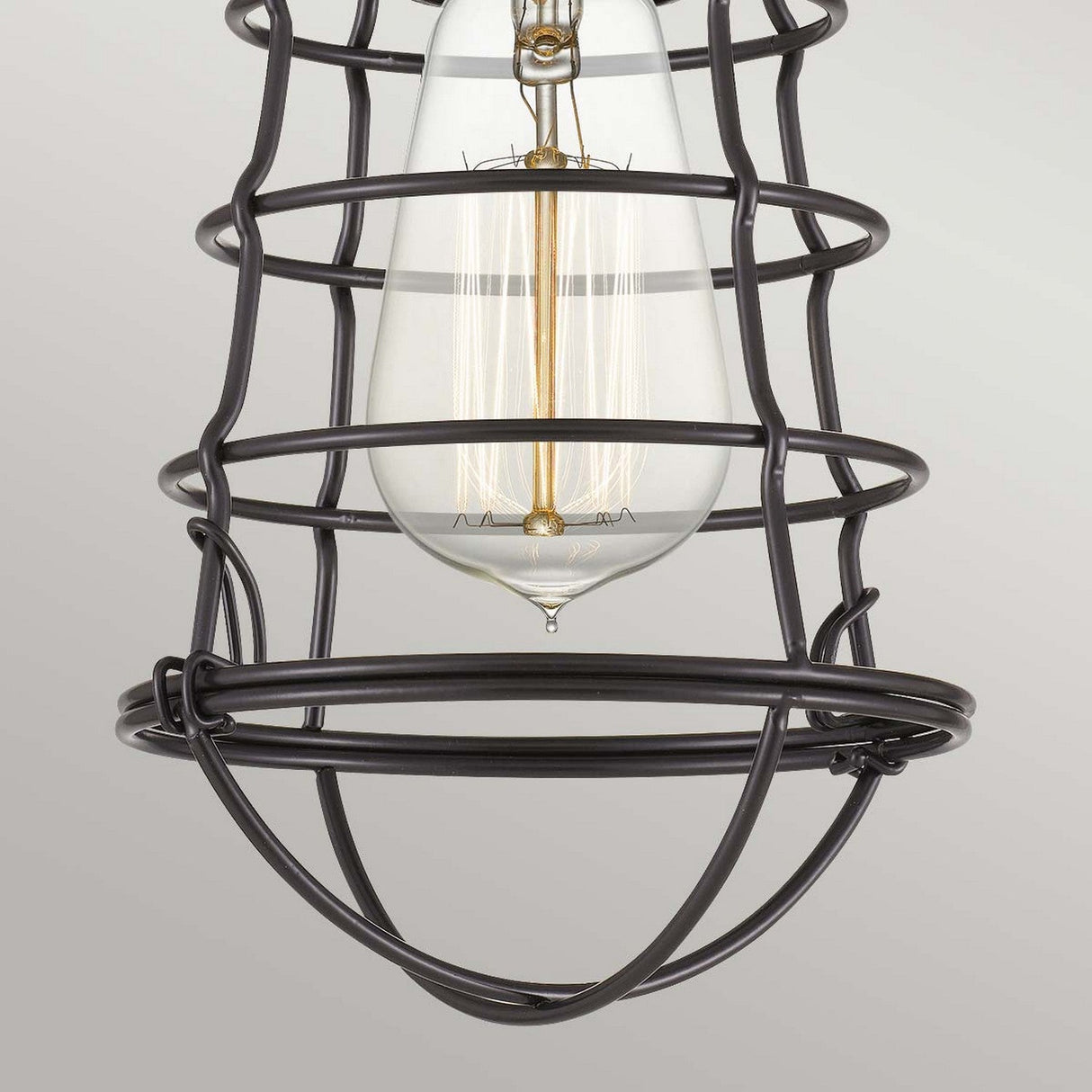The Mixon 1 Light Semi-Flush in Palladian Bronze showcases a vintage-style bulb surrounded by a black metal cage design, highlighted with Palladian Bronze accents. The visible filament adds an industrial appeal and rustic charm against a neutral background.