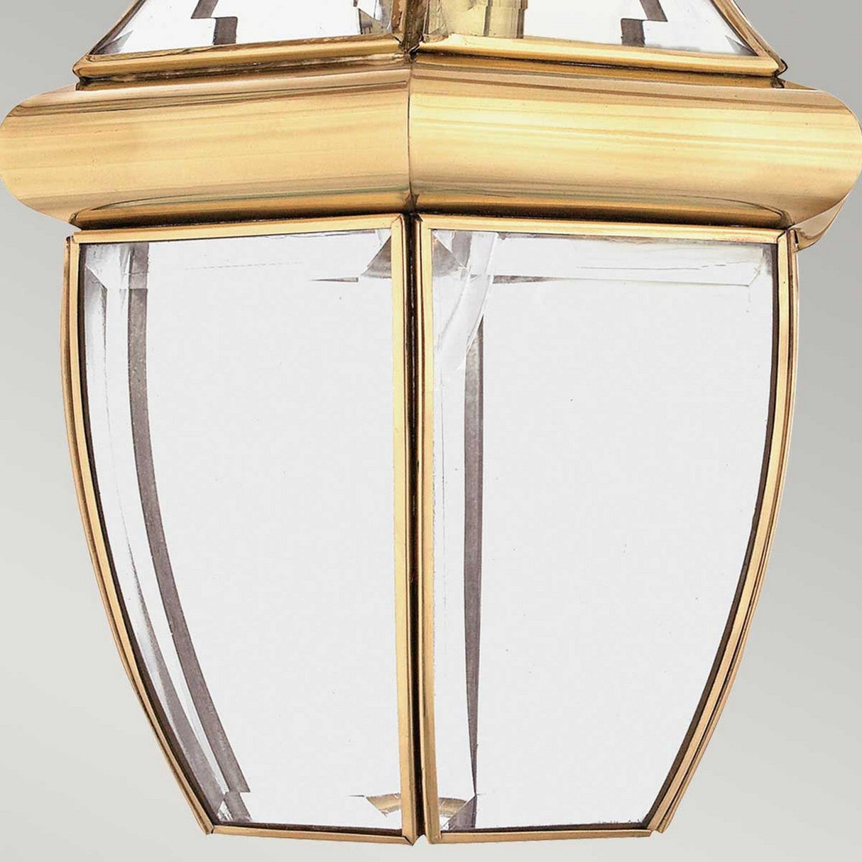 Close-up of the Newbury Outdoor 1 Light Medium Chain Pendant in lacquered polished brass, featuring a classic geometric design. It has four clear beveled glass panels set in its frame, offering a timeless and elegant appearance against a neutral background.