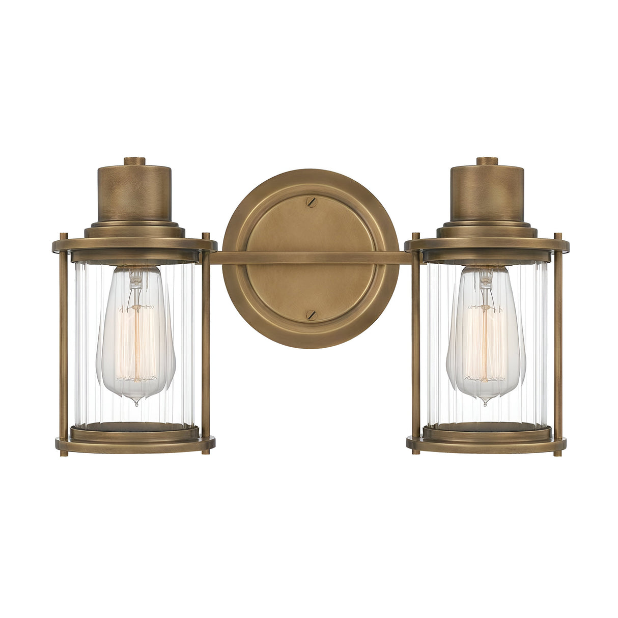The Riggs 2 Light Wall Light - Weathered Brass showcases two ribbed glass shades housing Edison bulbs, projecting an industrial aesthetic. The fixture features a weathered brass finish and a circular mounting plate, with the bulbs positioned side by side for a stylish appearance.