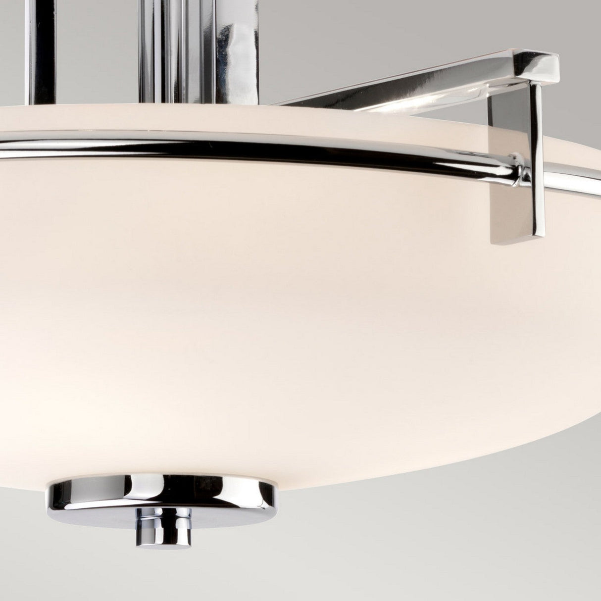 Close-up of the Taylor 3 Light Semi-Flush - Polished Chrome ceiling fixture with opal etched glass and shiny metallic accents, suspended from a polished chrome bracket. The image emphasizes its sleek design against a neutral background.