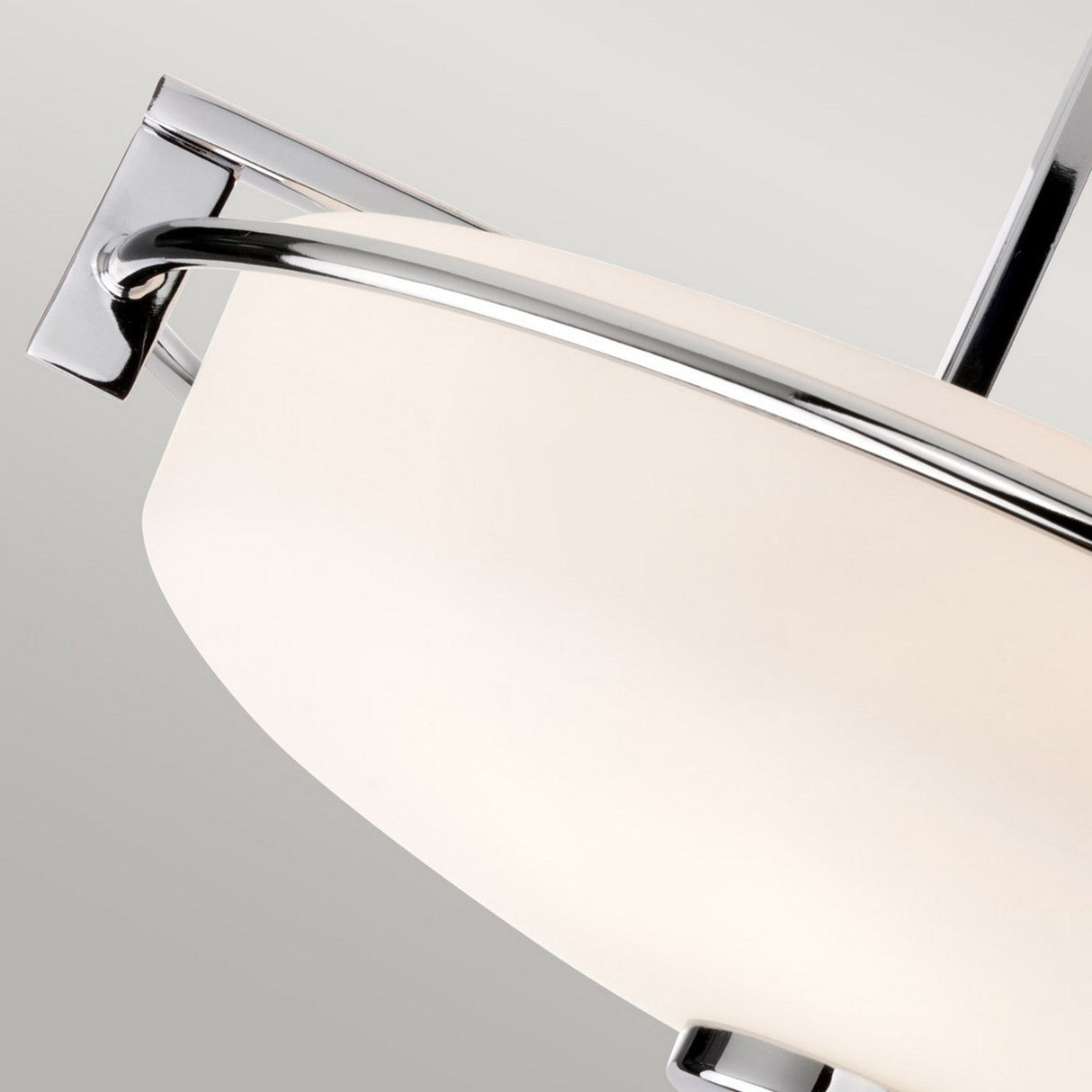 Close-up of a contemporary ceiling light fixture featuring a smooth, opal etched glass shade and a sleek polished chrome finish, evocative of the Taylor 3 Light Semi-Flush - Polished Chrome design, against a neutral backdrop.