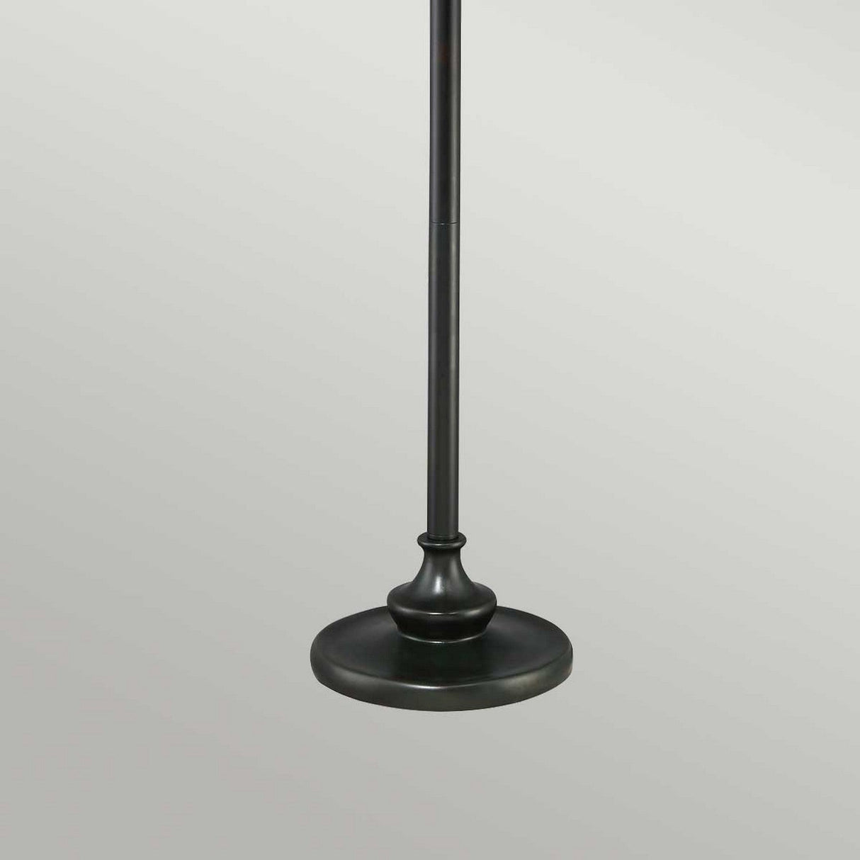 The Victory 2 Light Tiffany Floor Lamp in Valiant Bronze features a sturdy round base and a sleek pole that extends upwards, resembling the classic Tiffany floor lamp style. Its dark finish is beautifully contrasted against the light gray background, enhancing ambient lighting in the room.