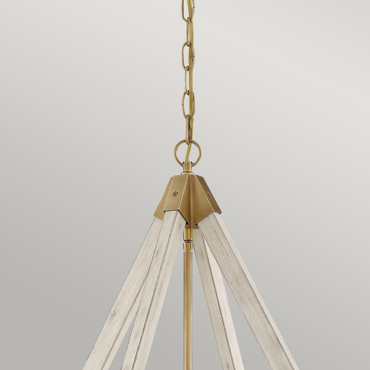 The View Point 4 Light Chandelier features a weathered brass chain and metal accents, with a design that emphasizes its whitewash wood effect through multiple triangular wooden slats converging at the top, all set against a simple light gray backdrop.