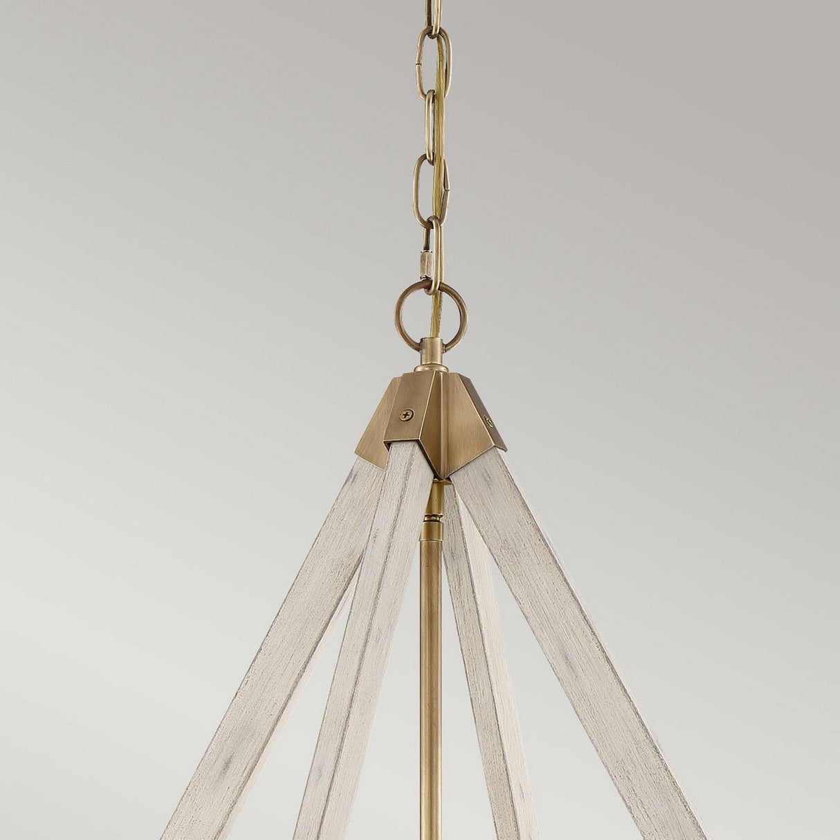 The View Point 3 Light Chandelier, featuring a triangular frame, is suspended from a chain against a neutral backdrop. It showcases a whitewash wood effect that pairs beautifully with the weathered brass accents, enhancing its farmhouse charm.