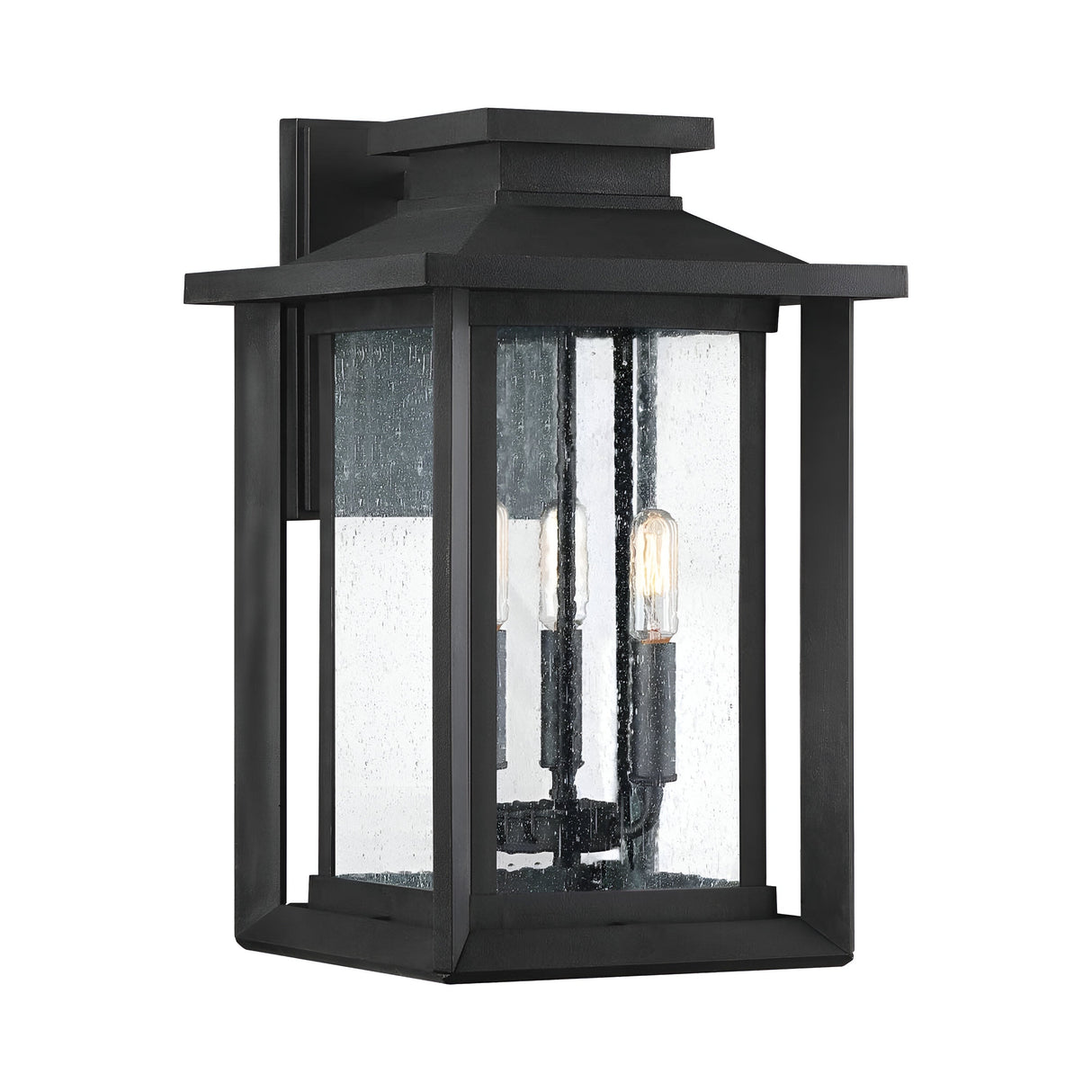 The Wakefield Outdoor 3 Light Large Wall Lantern in Earth Black showcases a black, rectangular design with clear, textured glass casing and three visible bulbs. Its classic Arts and Crafts style brings an elegant touch to any exterior setting.