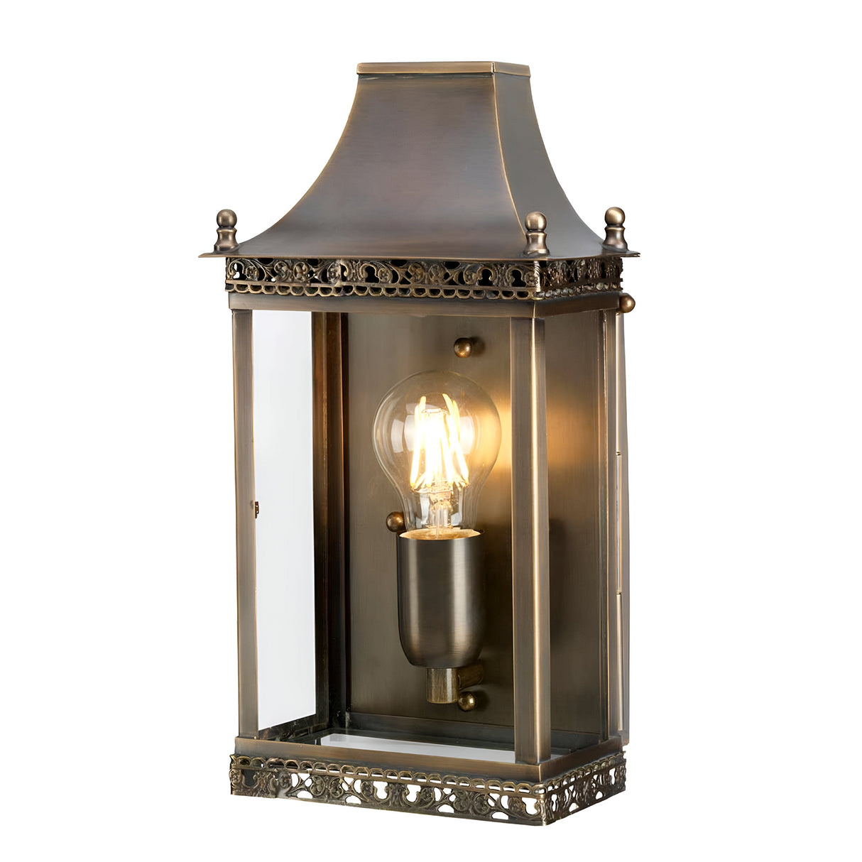 The Regents Park 1 Light Outdoor Wall Light in aged brass beautifully highlights a visible light bulb within a rectangular glass encasement. Rated IP44, this outdoor wall fixture boasts intricate detailing with a decorative top and ornate trim, making it an ideal choice for enhancing vintage-style settings.