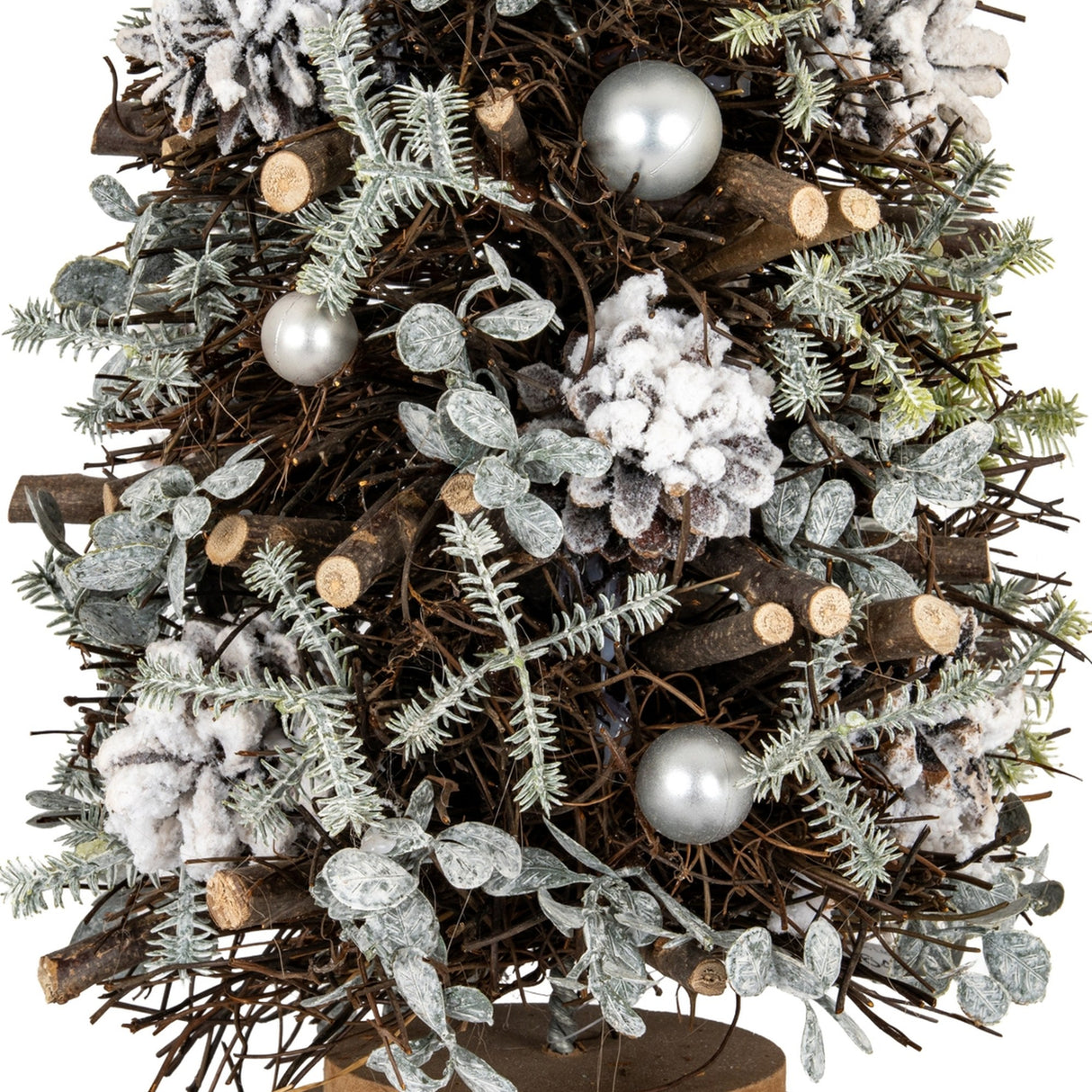 Close-up of Hill Interiors Large Frosted Forest Tree showing twig branches, frosted needles, snow-dusted pinecones and silver pearl baubles on a wood base.