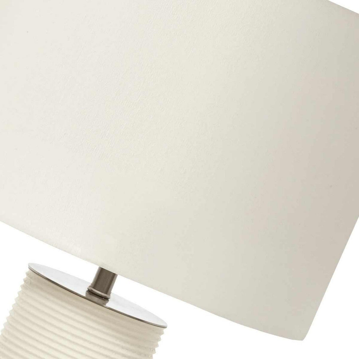 Close-up of the Ripple 1 Light Table Lamp - White with White Shade, highlighting its textured cylindrical base and smooth white shade. The minimalist design incorporates a sleek metal accent linking the base to the shade, all elegantly photographed against a plain background at an angle.