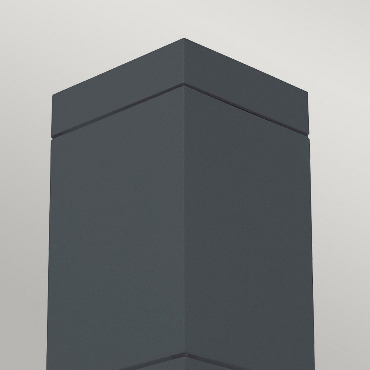 Against a light gray backdrop stands the Sandvik Outdoor 1 Light Down Ceiling Light, featuring a tall, dark gray rectangular column with a sleek graphite finish. Its minimalist design showcases clean lines and comes with an IP65 rating, making it ideal for outdoor use.