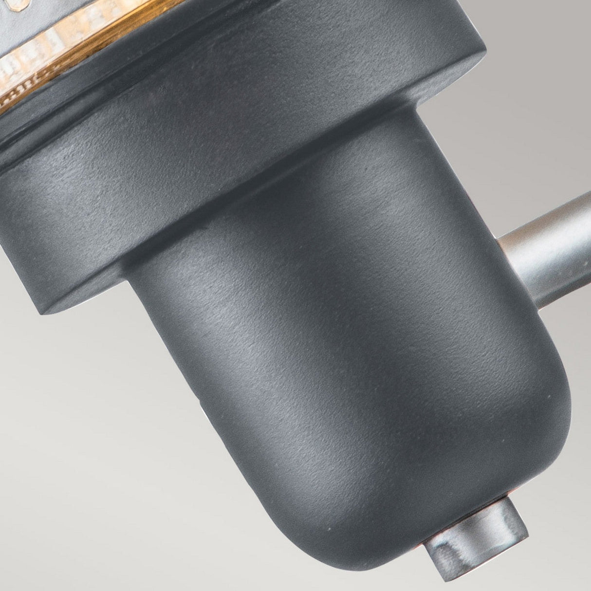 Close-up of the Saturne 1 Light Outdoor Wall Light in a sleek matte black finish, showcasing its cylindrical shape with a prominent metallic arm and silver mesh diffuser. The soft gray background highlights its sophisticated design.