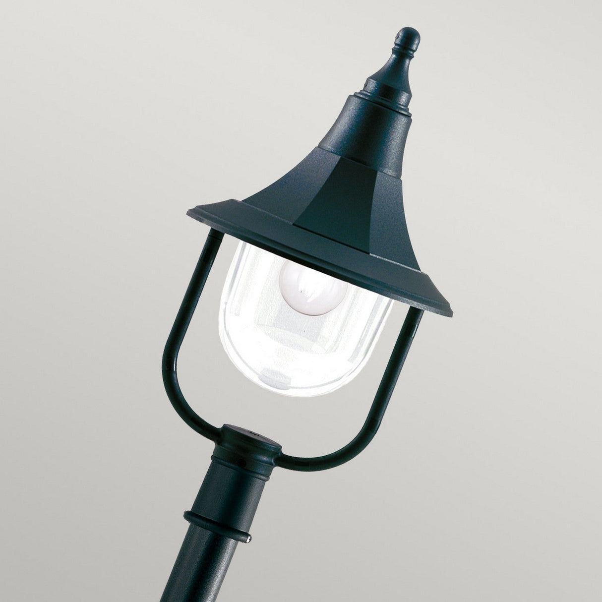 The Shannon 1 Light Pillar in black boasts a traditional design, featuring a central light bulb encased in clear glass. This weather-resistant outdoor lantern is elegantly displayed against a simple light gray background.