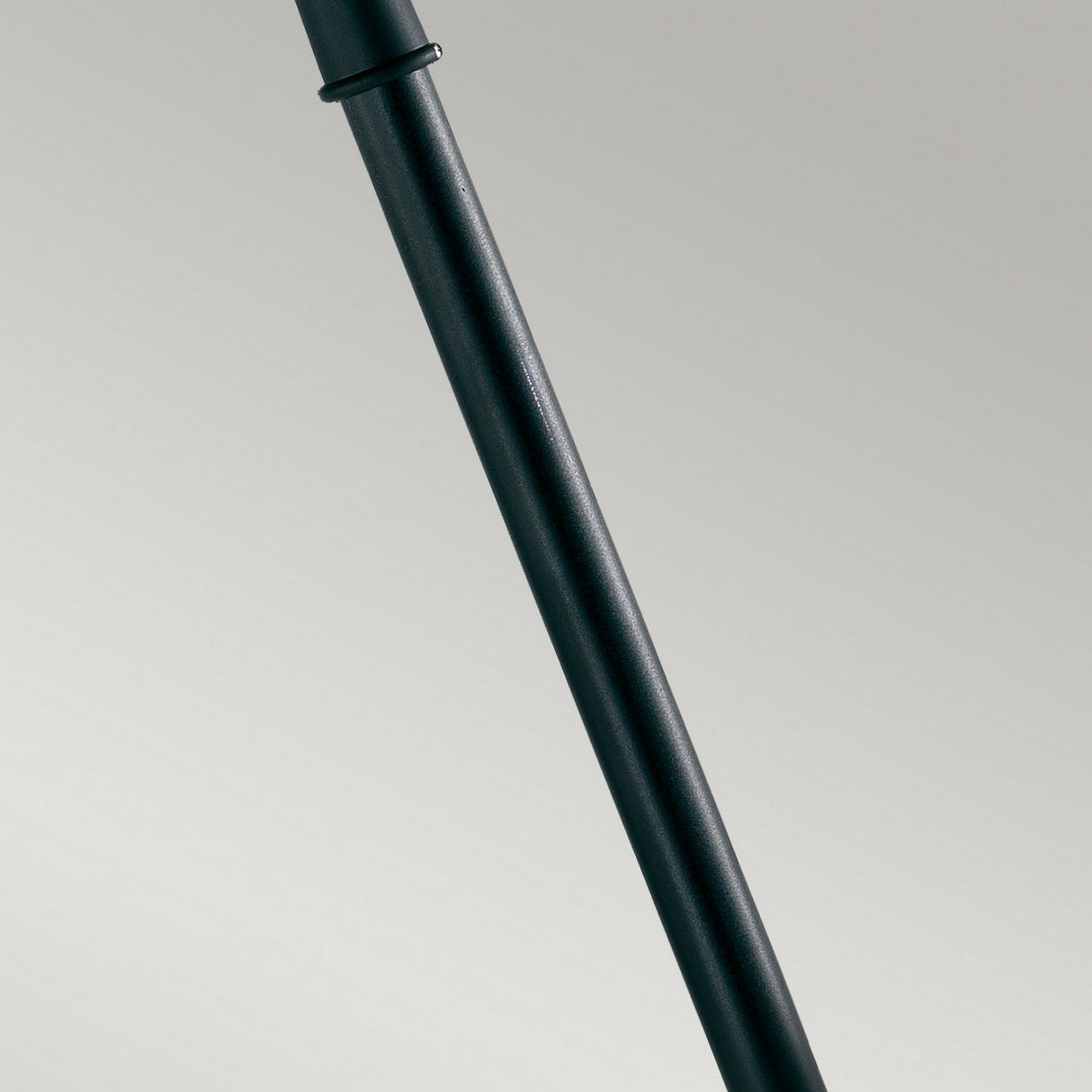 Close-up of the Shannon 1 Light Pillar - Black, a sleek, dark-colored metal rod, corrosion-proof and weather-resistant, positioned diagonally against a neutral, light gray background.