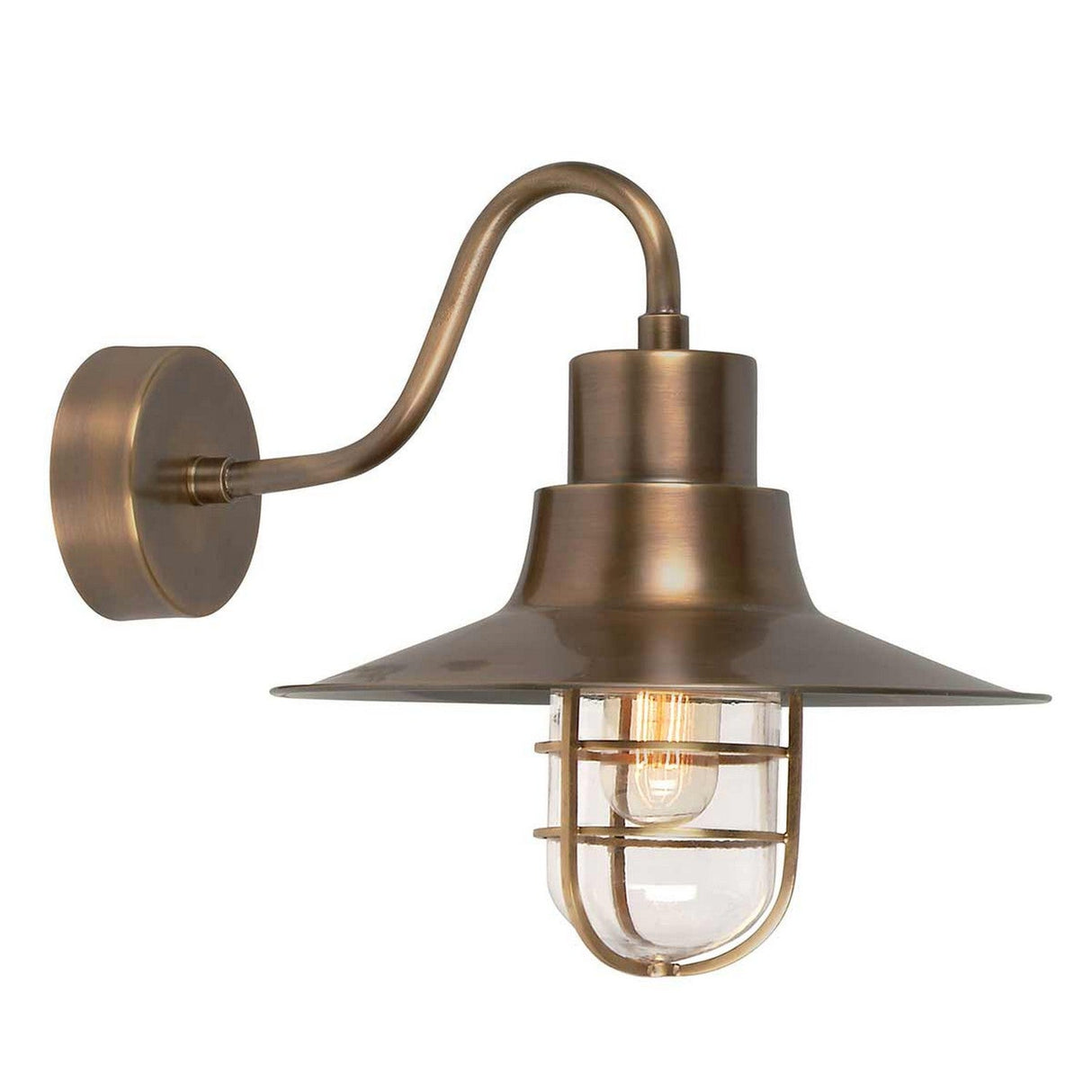 The Sheldon 1 Light Outdoor Wall Light - Aged Brass combines vintage appeal with industrial charm, featuring an aged brass finish and a curved arm. It is designed with a wide, flat shade, a clear glass cover, and a protective metal cage that reveals a visible filament bulb.