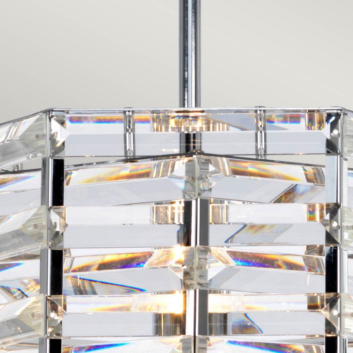 A detailed view of the Shoal 1 Light Pendant - Polished Nickel showcases its contemporary design, with layered clear crystal or glass panels encased in a polished nickel frame. The light reflects through the prisms, producing a sparkling effect.