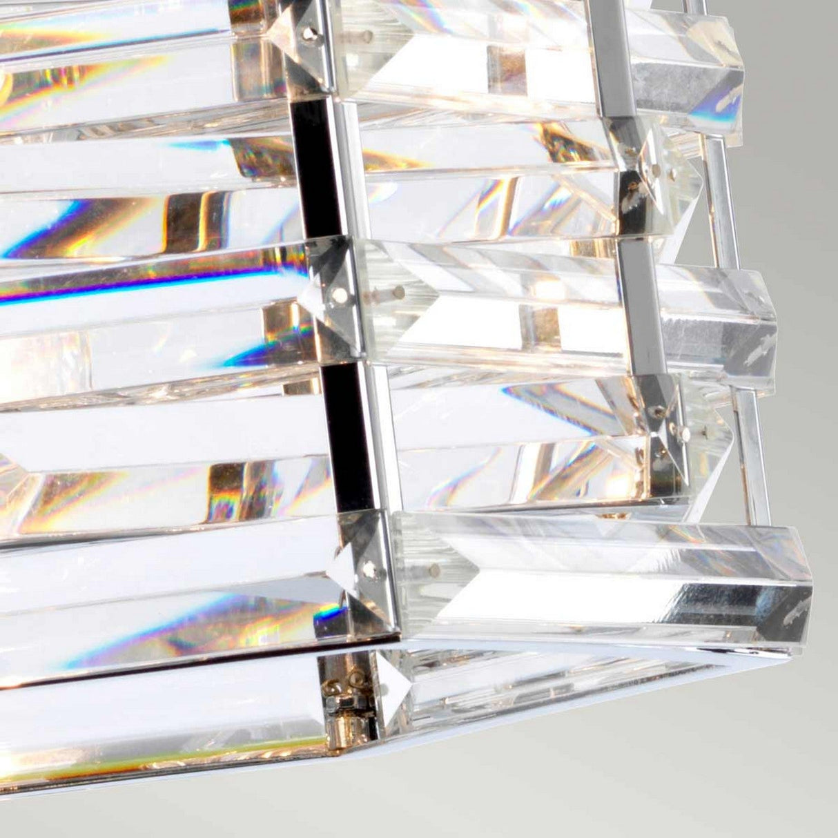A close-up of the Shoal 1 Light Pendant – Polished Nickel, featuring rectangular, faceted crystal prisms in a sleek polished nickel frame. The contemporary crystals reflect rainbow hues, creating a shimmering effect against a soft gray backdrop.