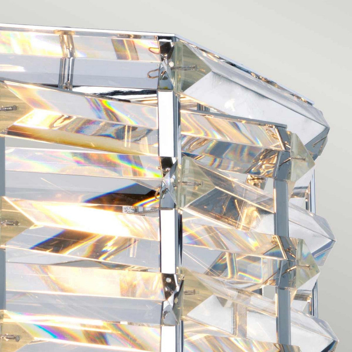 A close-up of the Shoal 4 Light Chandelier in its polished nickel finish showcases its multifaceted, prism-like glass structure, which reflects light to create colorful crystal-like reflections. The sharp angles and edges enhance its geometric and modern design, exuding the elegance typical of luxury lighting.