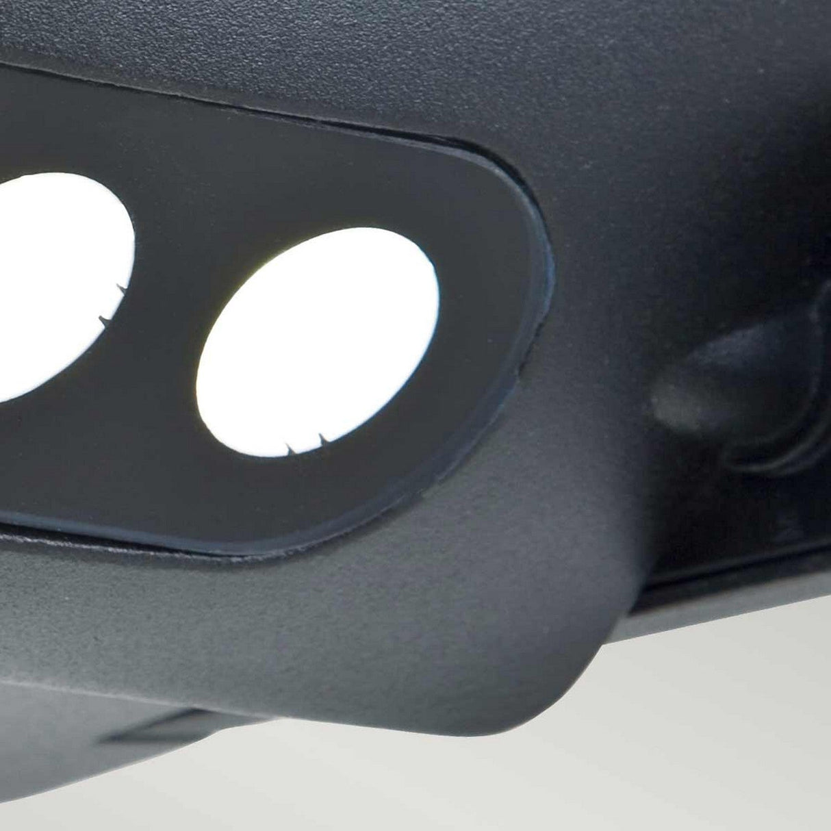 Close-up of a sleek black VR headset with two white circular lenses visible, reminiscent of the design seen in the Sigmund 3 Light Outdoor Wall Light — Graphite, set against a neutral background.