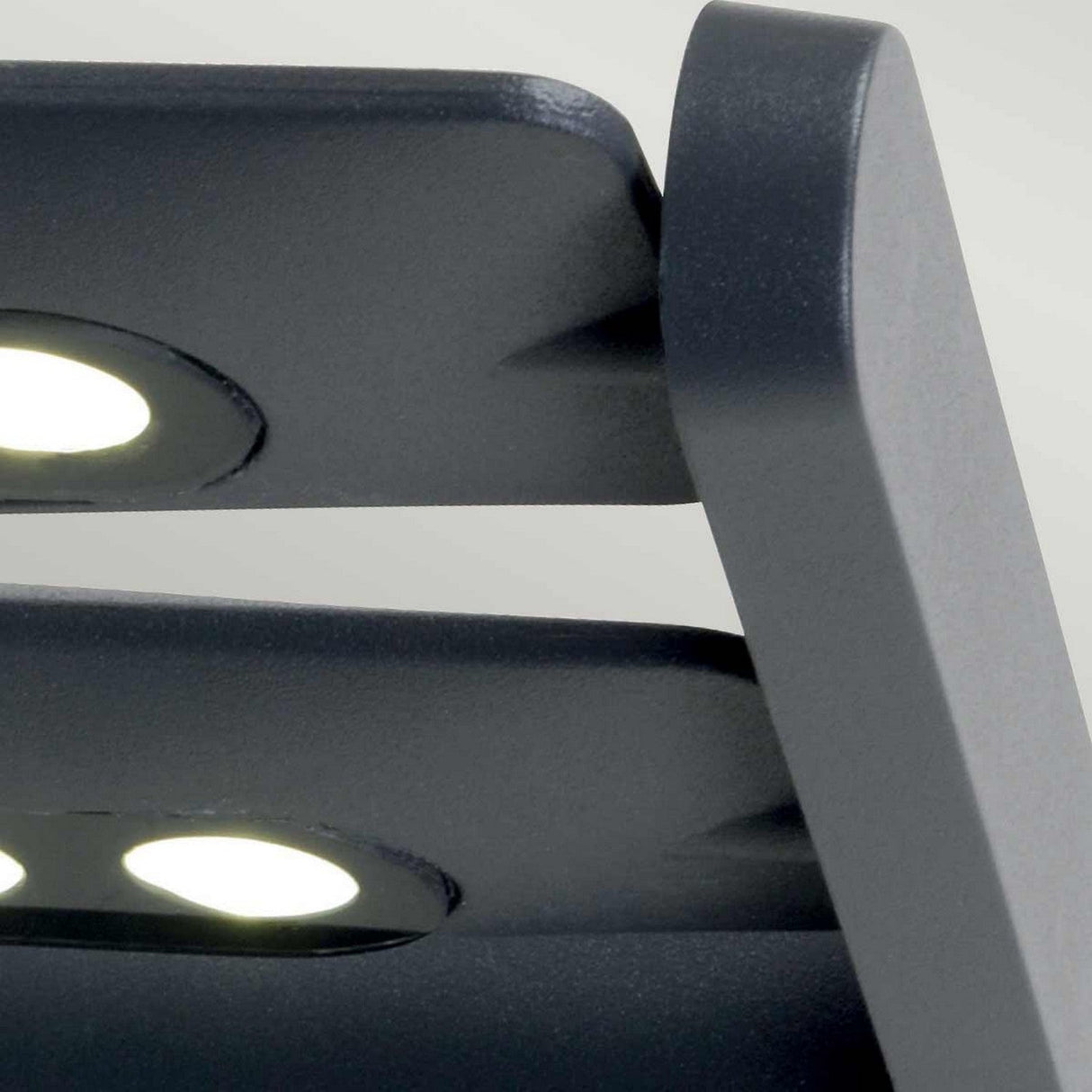 This close-up features the Sigmund 6 Light Outdoor Wall Light, showcasing advanced LED technology with its dual circular LED lights. The lamp boasts a sleek, minimalist design in a graphite finish, set against a light gray background.