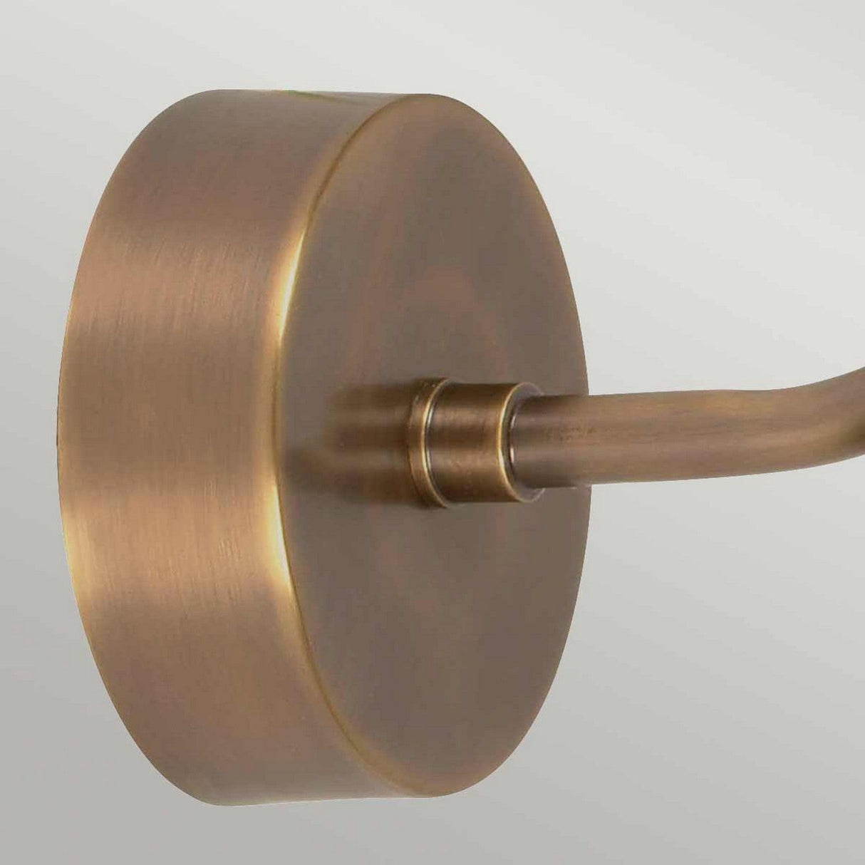 A close-up of the Somerton 1 Light Outdoor Wall Light in aged brass, featuring an extending arm. The smooth, metallic surface subtly reflects light, highlighting its warm tone and vintage design against a neutral background.