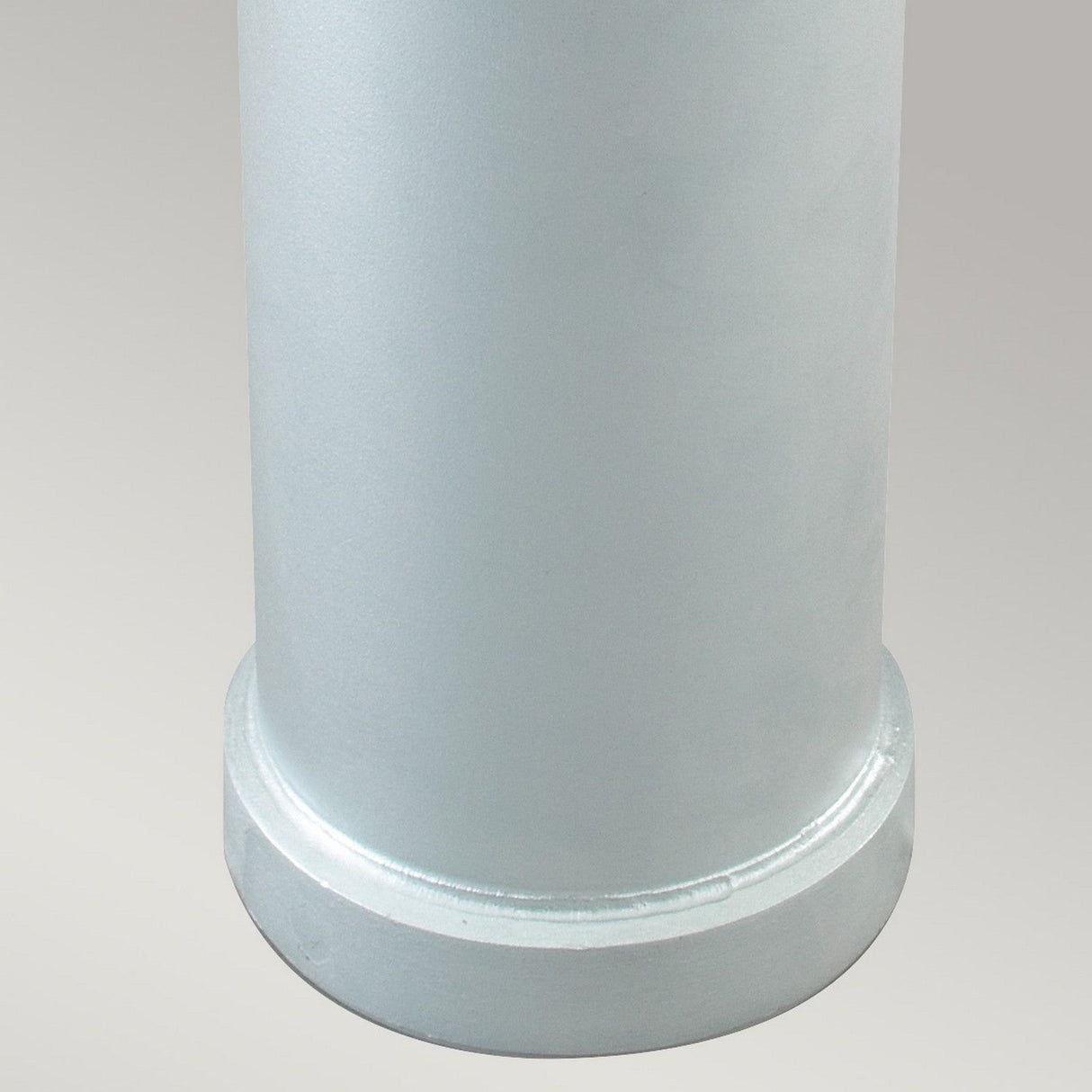 Close-up of the Stockholm Medium Bollard - Silver, a metallic cylindrical object made from galvanized steel, featuring a smooth, rounded base set against a light gray background.
