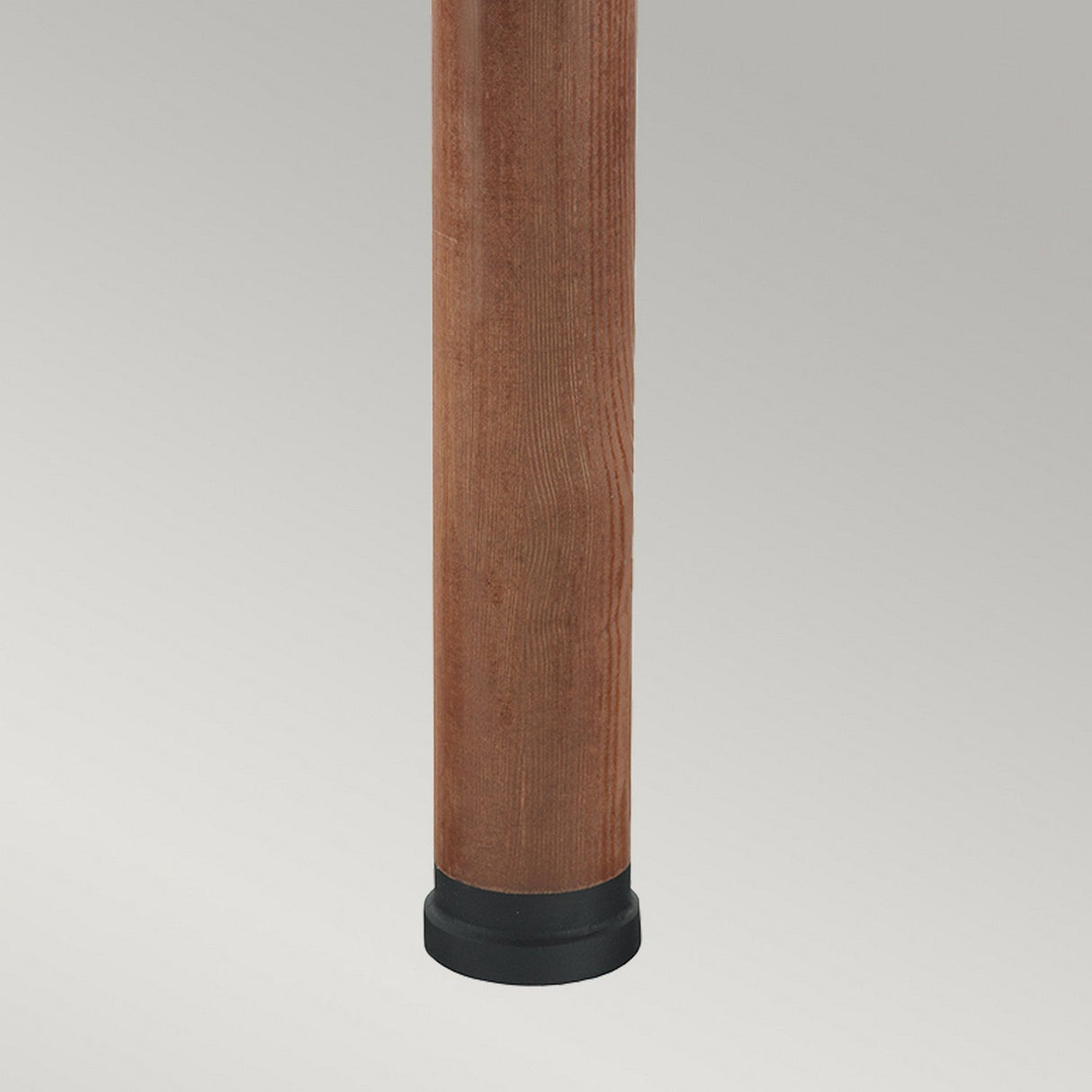 A vertically oriented leg with a cylindrical design, made from smooth brown stained wood, is topped with a black rubber tip at the base for added stability and floor protection. The background showcases a simple gradient transitioning from light to dark gray, reminiscent of the Stockholm Large Bollard Stained Wood - Black.