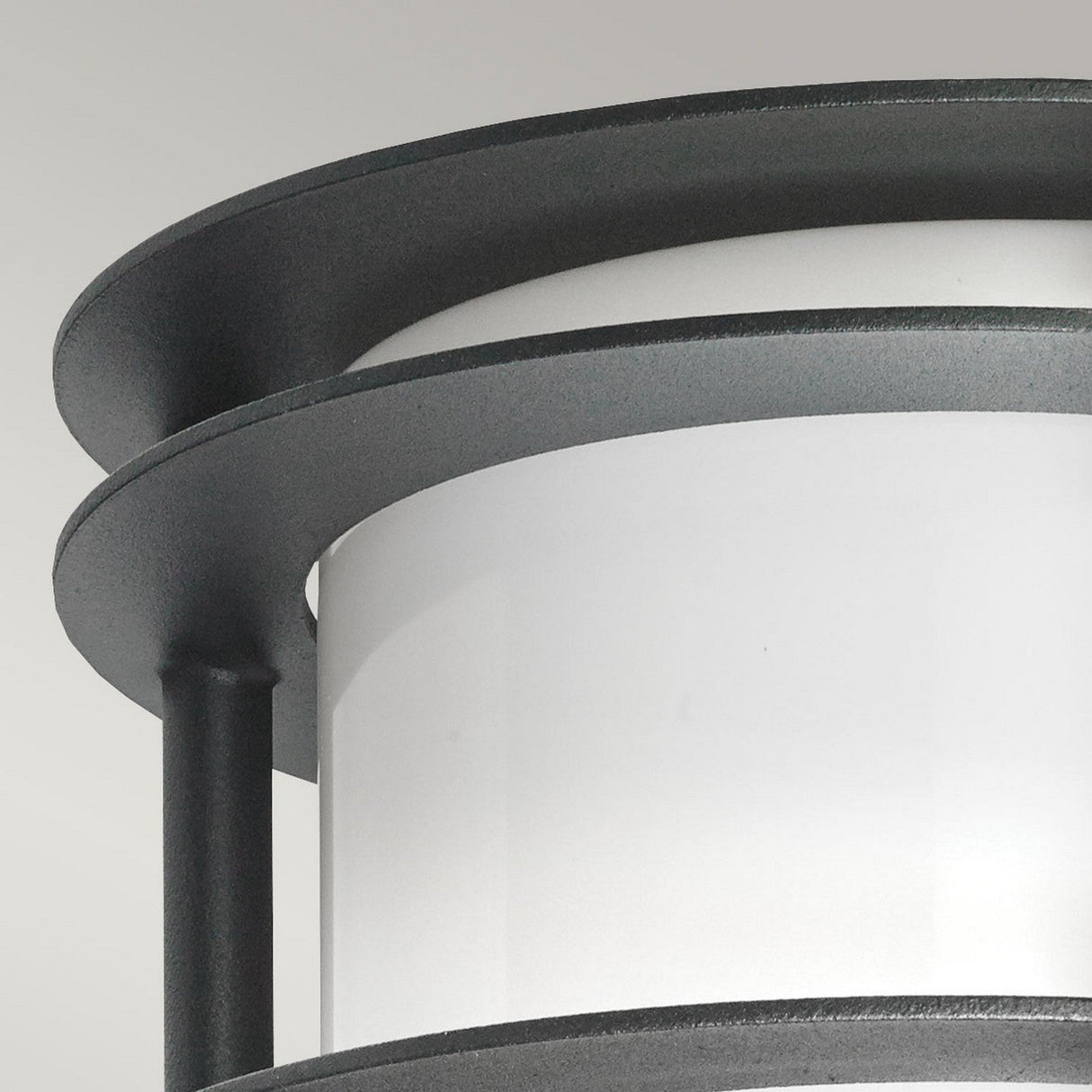 Featuring a detailed view of the Stockholm Outdoor 1 Light Flush Light, this modern wall fixture combines cylindrical elegance with a sleek design. It includes corrosion-resistant black metal rings and an opal glass center, creating a chic, contemporary appearance against a neutral background—ideal for refined outdoor lighting solutions.