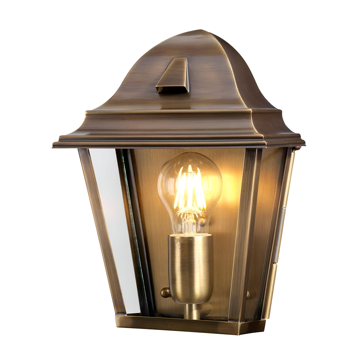 The St James 1 Light Outdoor Wall Light in aged brass boasts a traditional British design, complete with a clear glass pane that elegantly frames the illuminated bulb. Featuring a gracefully curved top with a pointed tip, this fixture adds timeless charm to any outdoor space.