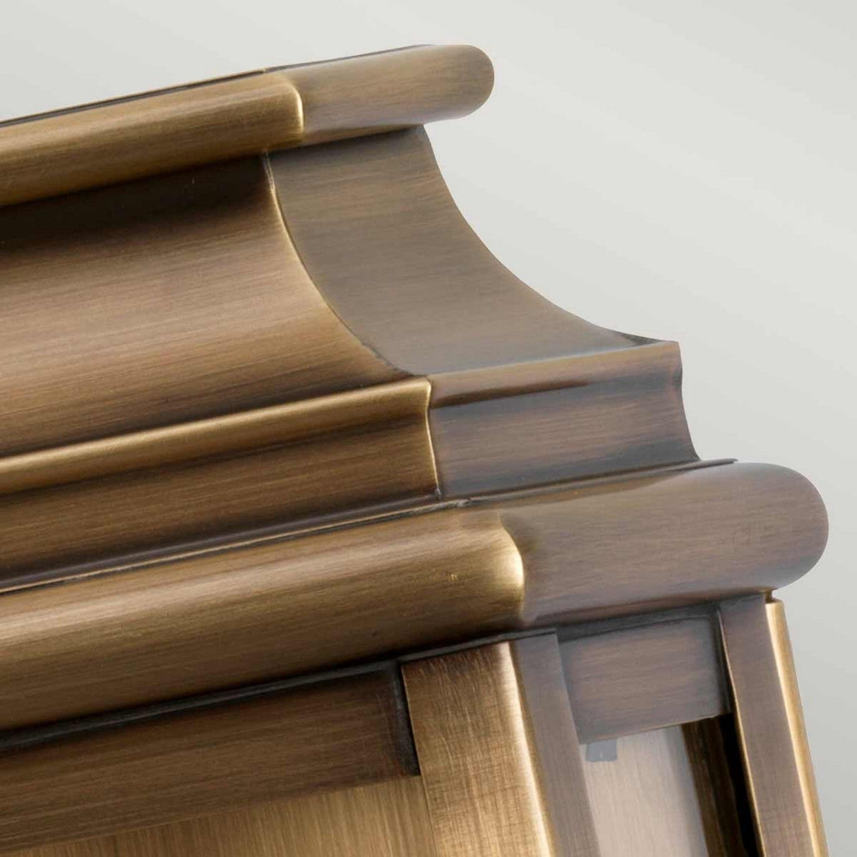 Close-up of the St Martins 1 Light Outdoor Wall Light in aged brass, featuring hand-crafted, ornate moldings and a smooth finish. The aged brass sheen and elegant curves echo a classic architectural style against a neutral background.