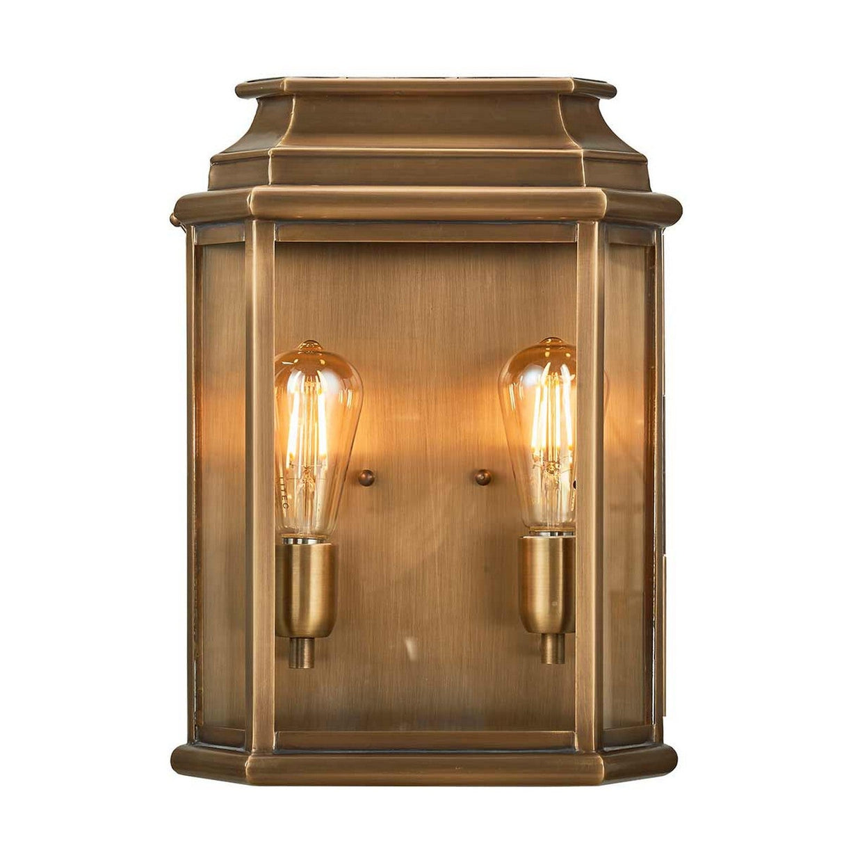 The St Martins 2 Light Outdoor Large Wall Light in aged brass exudes historical charm, featuring two exposed Edison bulbs within a rectangular frame of brass and glass.