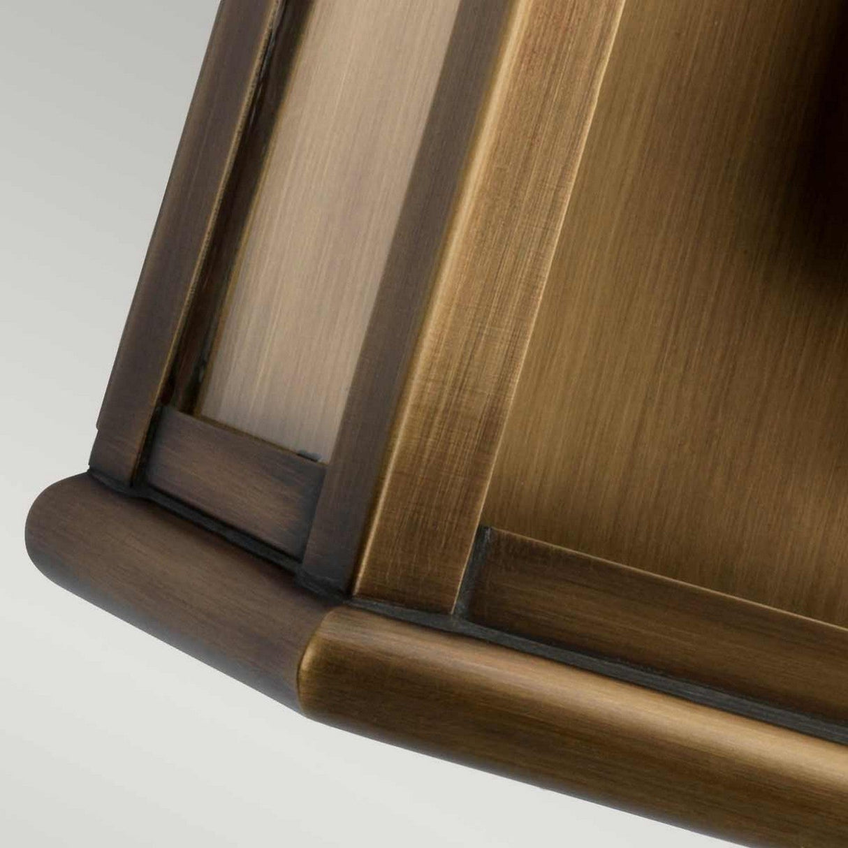 A detailed view of a section of the St Pauls 1 Light Outdoor Wall Light showcases its aged brass finish, evoking the warm bronze tone typical of a classic lantern. The smooth texture and meticulous craftsmanship highlight the light's elegant and timeless design, making it an ideal addition to any décor.