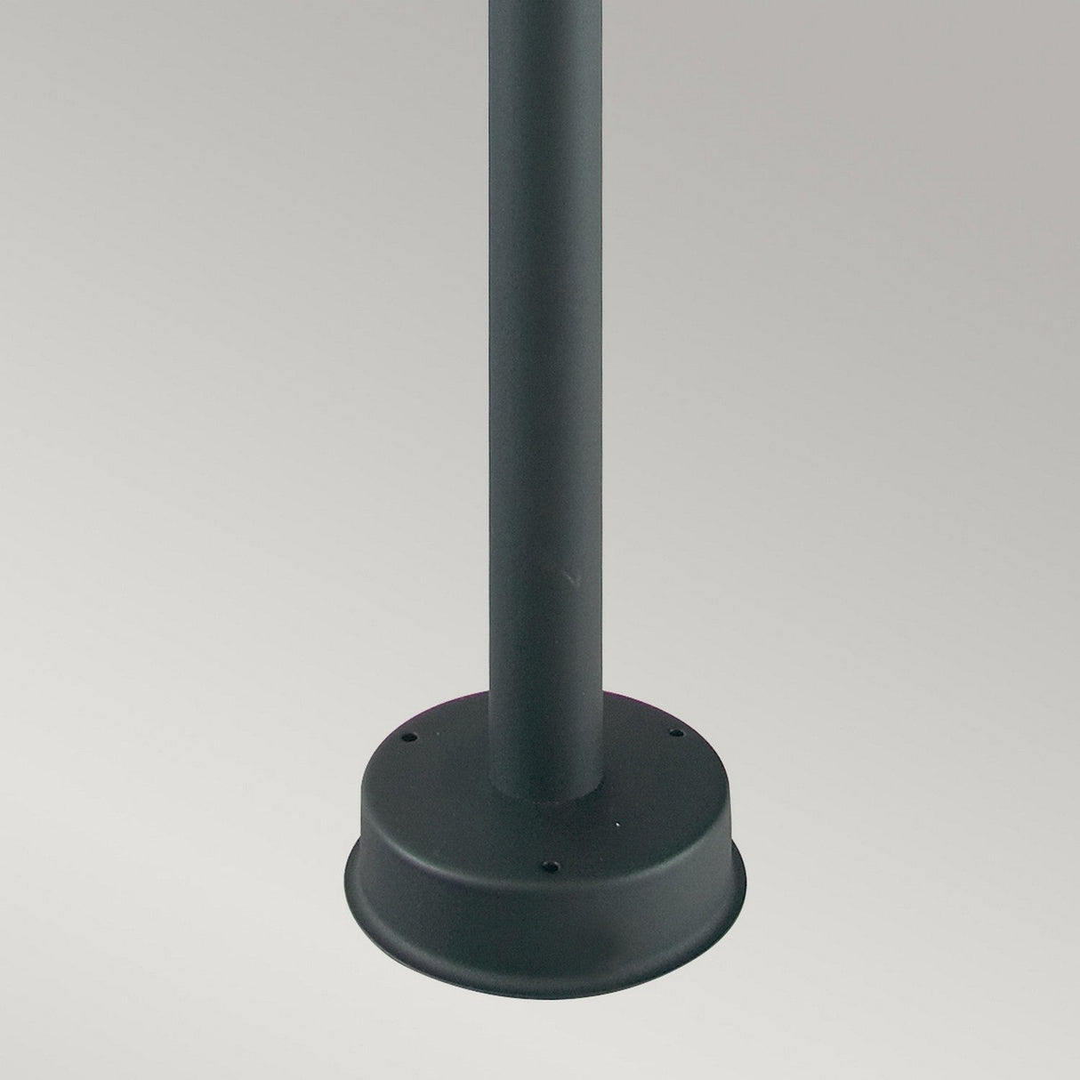 The Stockholm 1 Light Pillar - Black features a sleek, smooth design with a cylindrical shape, standing upright against a neutral gray background. Perfect for crowd control or barriers, it showcases durability with its galvanized steel construction and round base.