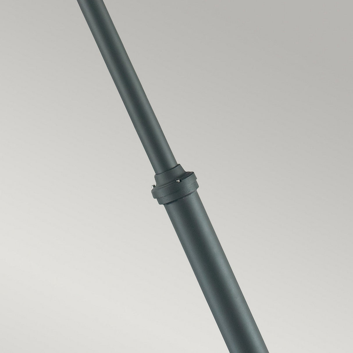 The Stockholm 1 Light Grande Lamp Post in black is shown in close-up against a neutral background, highlighting its sleek design reminiscent of Scandinavian simplicity. The metal pole has a connector or joint in the middle with visible screws, adding to its modern aesthetic.