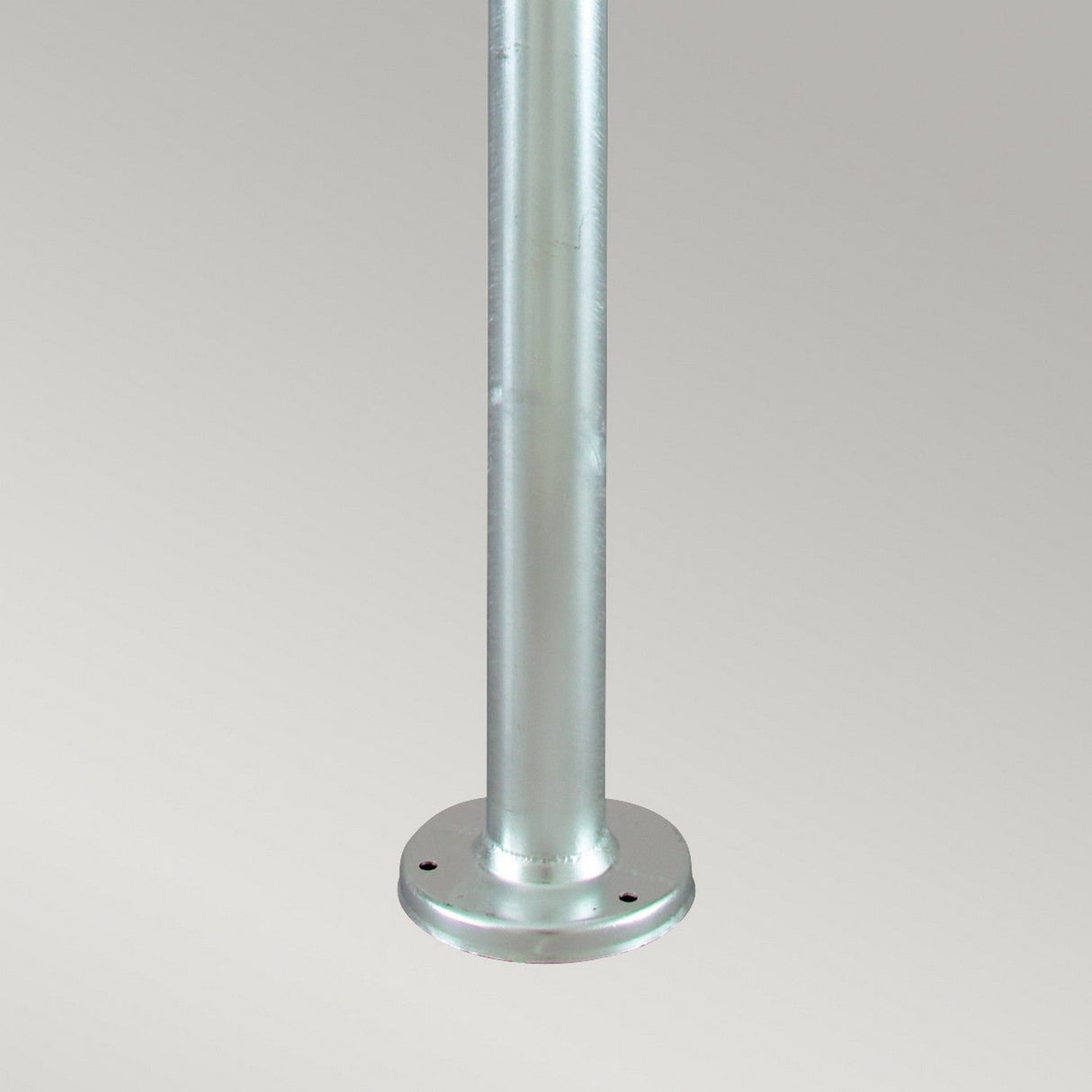 Against a plain background, the Stockholm 1 Light Grande Lamp Post in silver stands as a metallic cylindrical pole that echoes the classic aesthetic of a traditional Stockholm Lamp Post. Crafted from galvanized steel, it boasts a smooth and shiny finish. Its round base is designed with two visible holes for mounting, making it perfect for secure outdoor lighting installations.