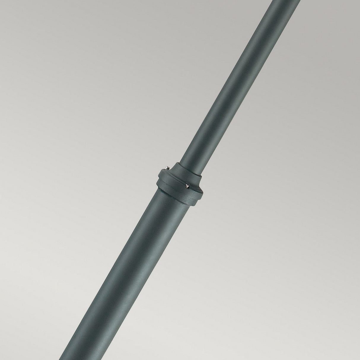 A close-up view of the Stockholm 2 Light Twin Lamp Post in black, showcasing its hollow metal structure with a connector, set against a light gray background. The design evokes Scandinavian-inspired elements and is positioned diagonally across the image, reminiscent of outdoor lighting fixtures.