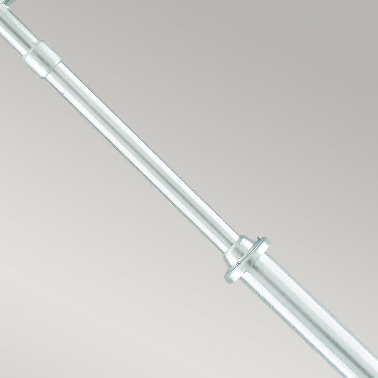 A close-up of the Stockholm 2 Light Twin Lamp Post - Silver, featuring a shiny, galvanized steel construction with evenly spaced rings and a smooth, reflective surface, set against a plain gray background. The Scandinavian-inspired design lends elegance and simplicity to its appearance.