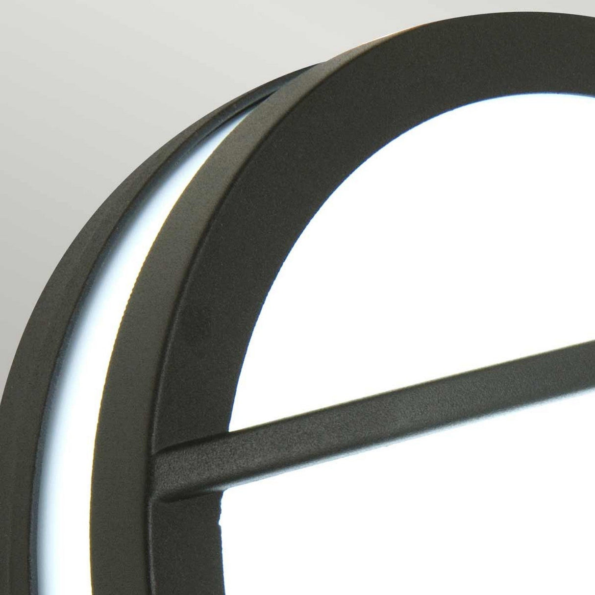 Close-up of the Sven 1 Light Outdoor Wall/Ceiling Light in a sleek round design made from die-cast aluminum with a graphite frame and glowing white center. This modern aesthetic piece is partially visible, intersected by a horizontal black bar crossing the white light, set against a soft gray background.