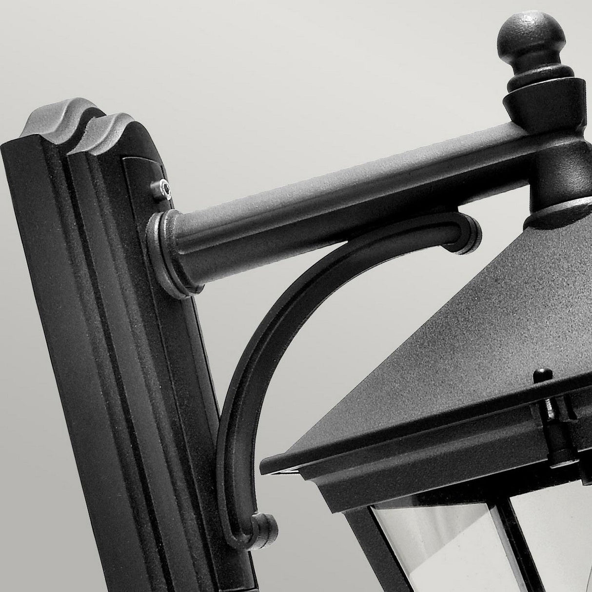 A close-up of the Turin Outdoor 1 Light Down Wall Lantern in black showcases its classic design, crafted from die-cast aluminum. The lantern is elegantly mounted on a stylish bracket with curved details, set against a simple, neutral background that highlights its elegant lines and IP54 rating for durability against the elements.
