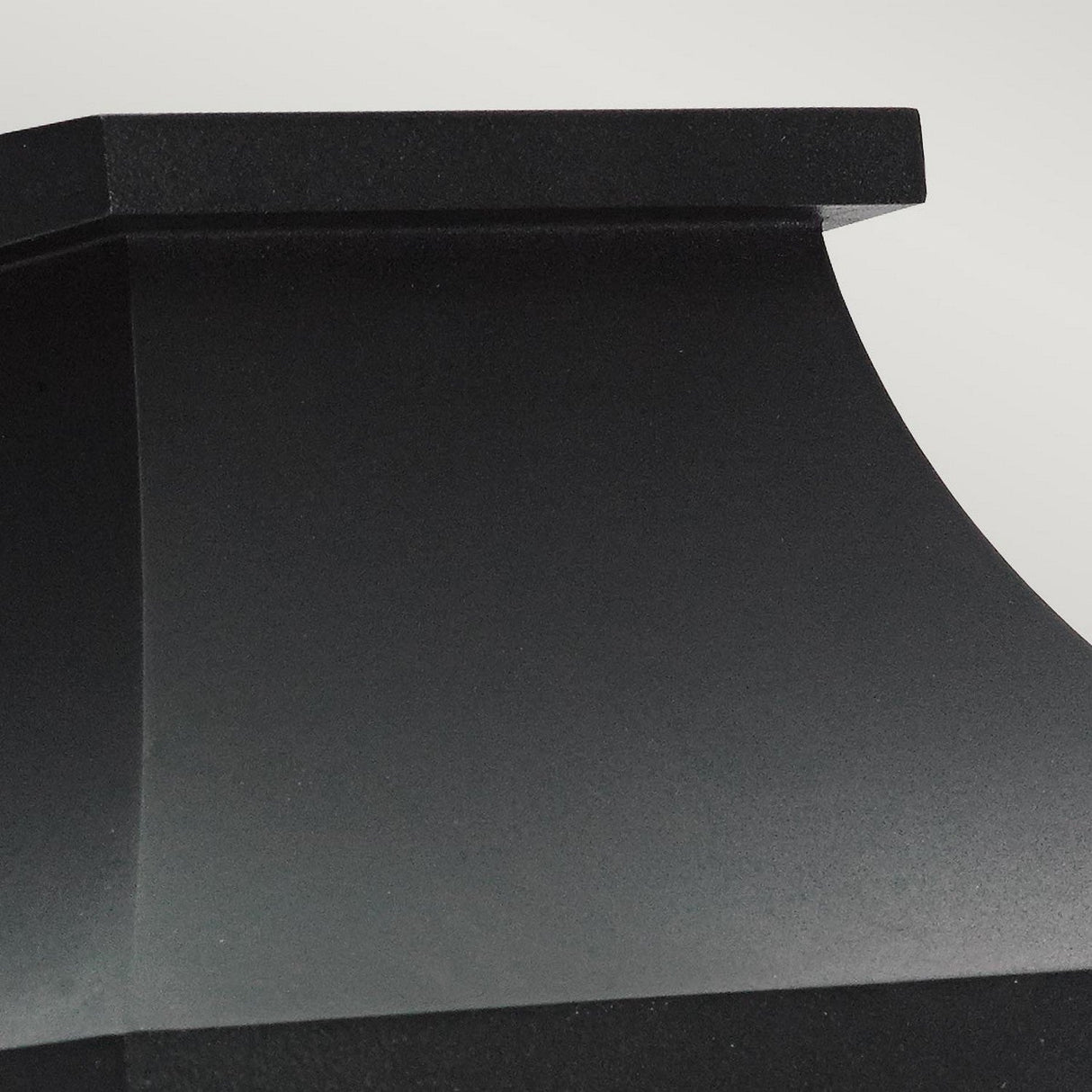 Close-up of the Turin Outdoor 1 Light Half Wall Lantern in black, set against a light gray background. This lantern is crafted from die-cast aluminum and features sleek, angular lines with a matte finish.