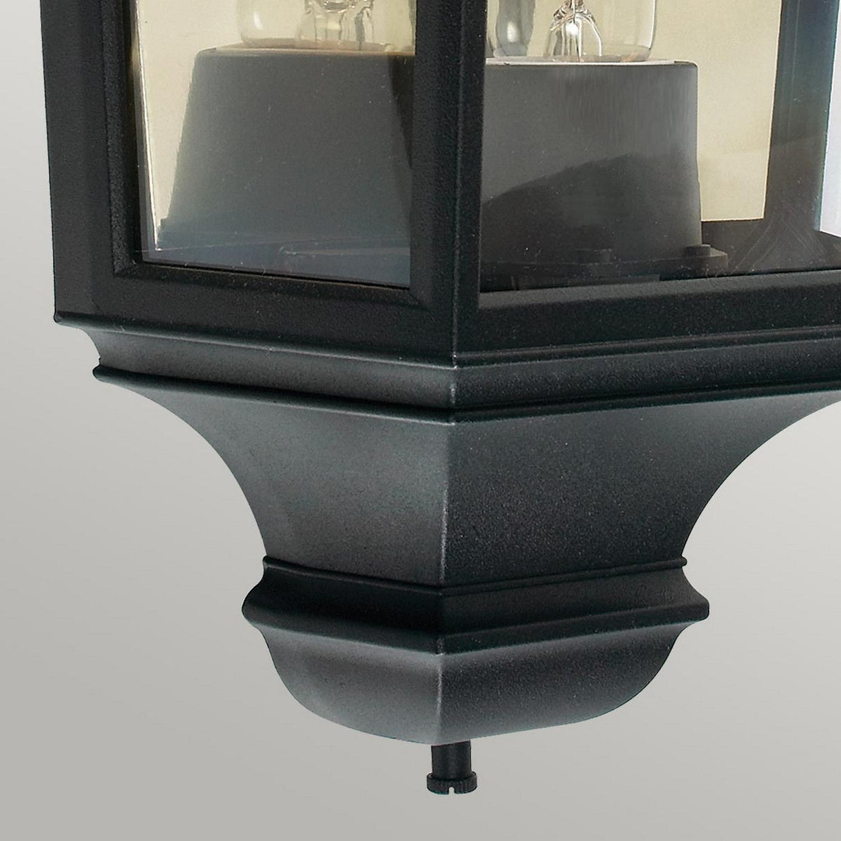 Close-up of the Turin Outdoor 1 Light Half Lantern in black, designed with a classic style and crafted from die-cast aluminum featuring glass panels. The lantern has a square base, accommodates one light bulb, and is rated IP54. The background is a neutral gray.