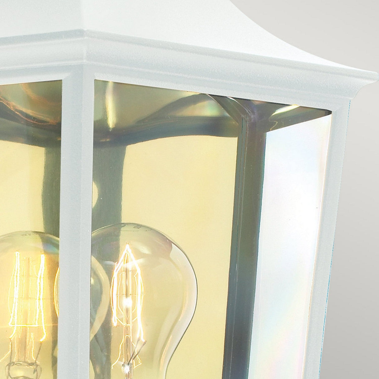 Close-up of the Turin Outdoor 1 Light Half Lantern in white, constructed from die-cast aluminum. Its transparent glass panel reveals a glowing light bulb inside, casting a gentle reflection that adds subtle colors to the surrounding area. This creates a warm and inviting ambiance, ideal for outdoor lighting.