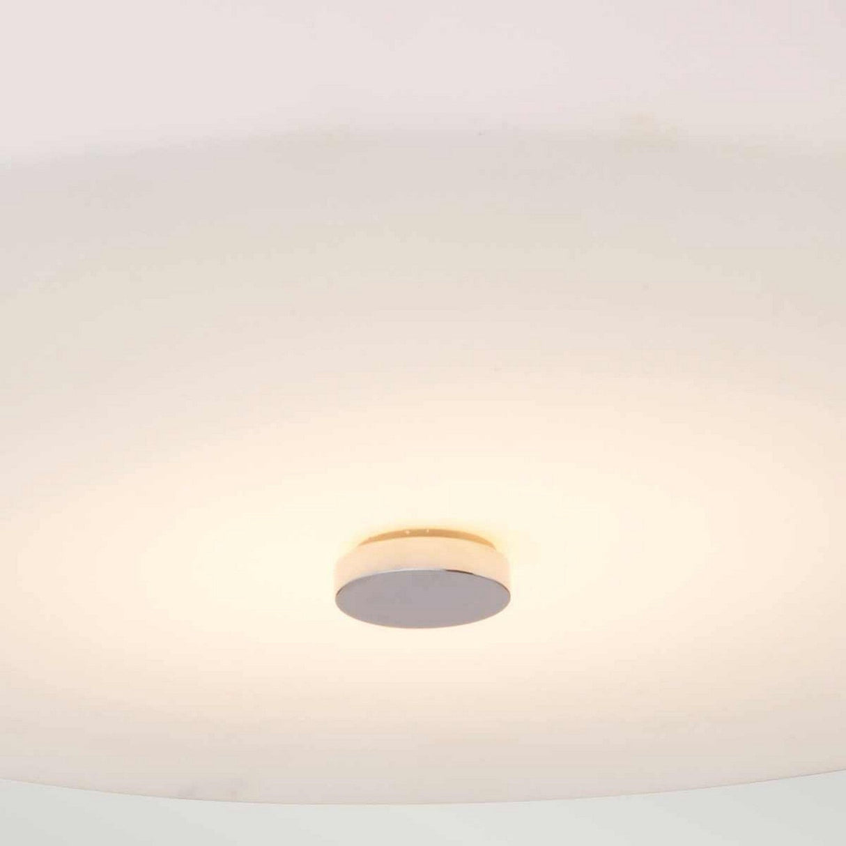 The Tamar 1 Light Large Flush in polished chrome offers a minimalist design, showcasing a round opal glass shade that emits a soft, glowing white light, complemented by a central metallic disk in polished chrome, seamlessly mounted on the ceiling.