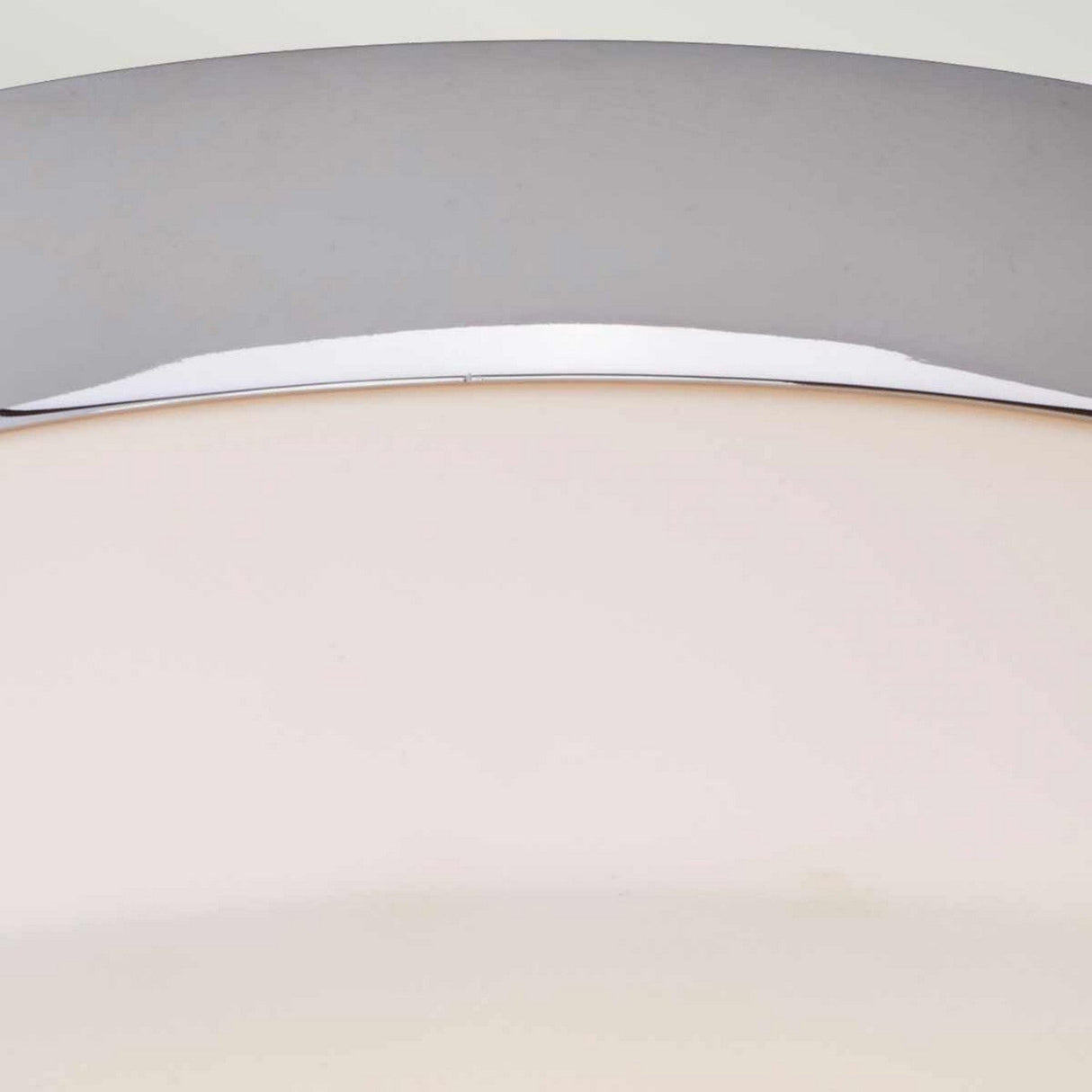 Close-up of the Tamar 1 Light Large Flush lamp, featuring a modern design with a semi-circular polished chrome frame and an opal glass cover. The sleek and minimalistic style provides soft lighting diffused through the material.