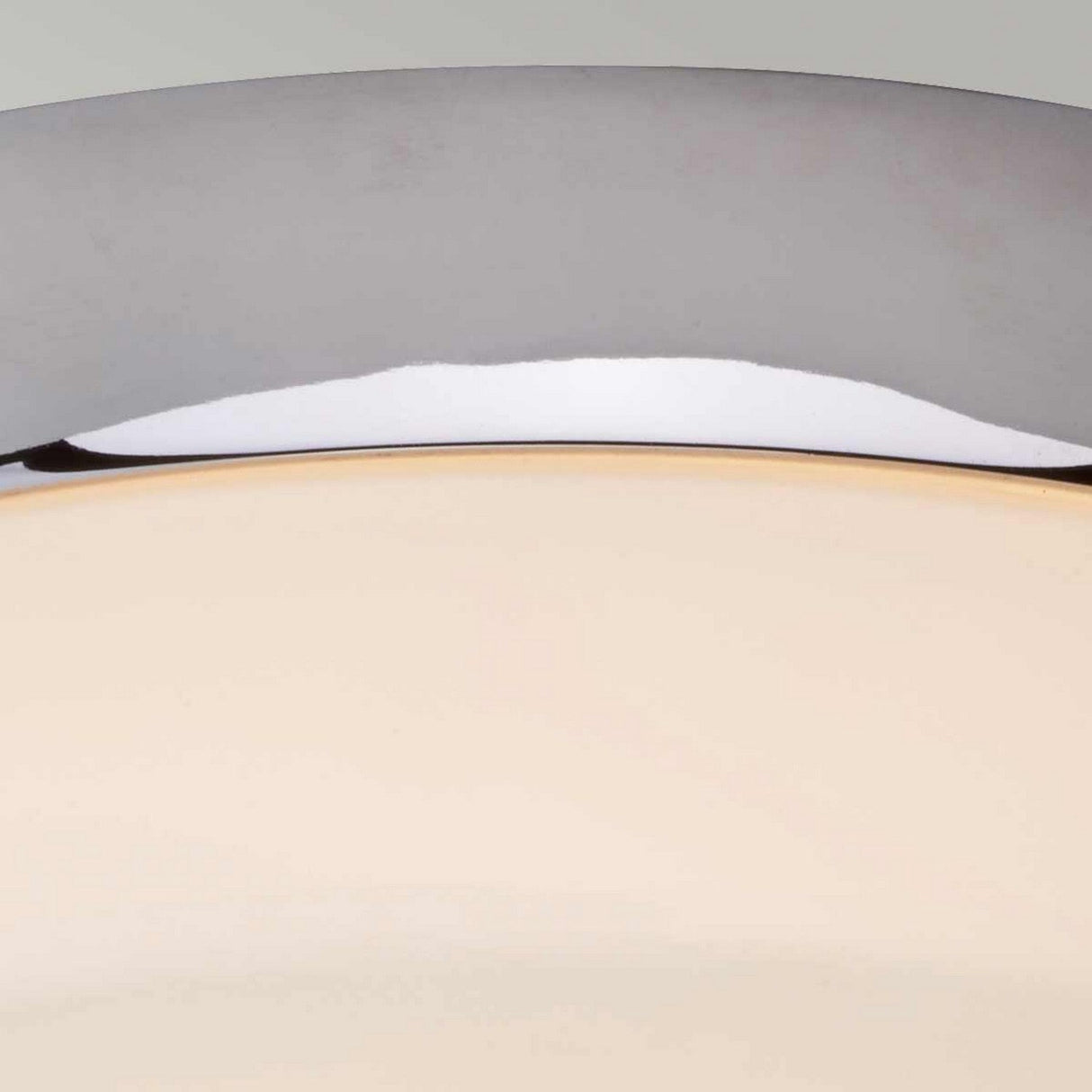 Close-up of the Tamar 1 Light Medium Flush in polished chrome, which features an opal glass diffuser that emits a warm, ambient glow against a neutral background.