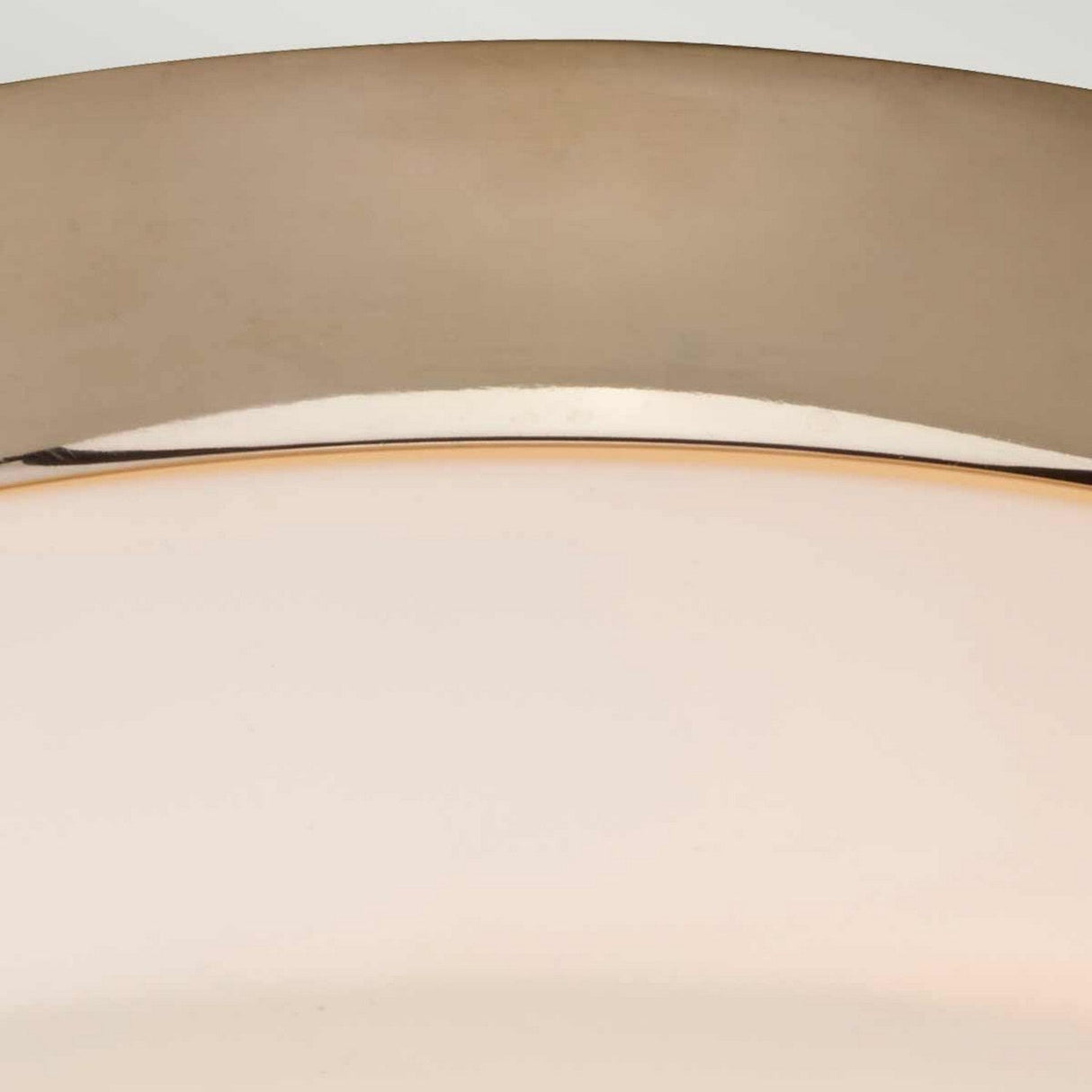 A close-up of the Tamar 1 Light Medium Flush - Polished Gold showcases its polished gold metallic rim and frosted glass. The light is turned off, emphasizing its sleek and simple design against a light gray background.