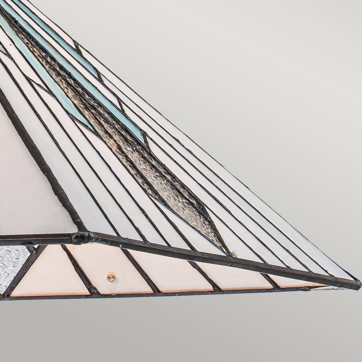 The Alderley 2 Light Tiffany Pendant in Vintage Bronze showcases a geometric stained glass lampshade with triangular panels in white, blue, and textured clear glass. This design is highlighted by dark metal outlines with a touch of vintage bronze, reflecting Art Deco styling against a subtle gradient of light gray.