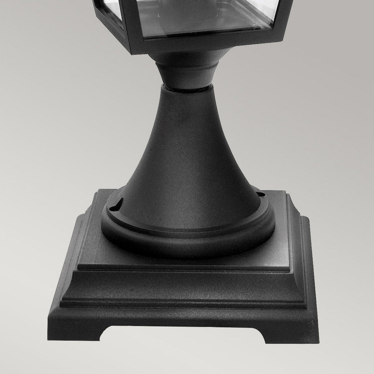 Close-up of the Turin Large 1 Light Pedestal in black, featuring a square lamp post base with a modern, sleek design. Made from die-cast aluminium, this sturdy base showcases a smooth, matte finish against a plain gray background—adding an elegant touch to any outdoor lighting arrangement.