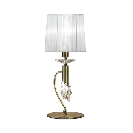 The Tiffany 2 Light Crystal Table Lamp features a brass base, curved stem, hanging crystal accents, and a white pleated shade, adding classic elegance to any room.
