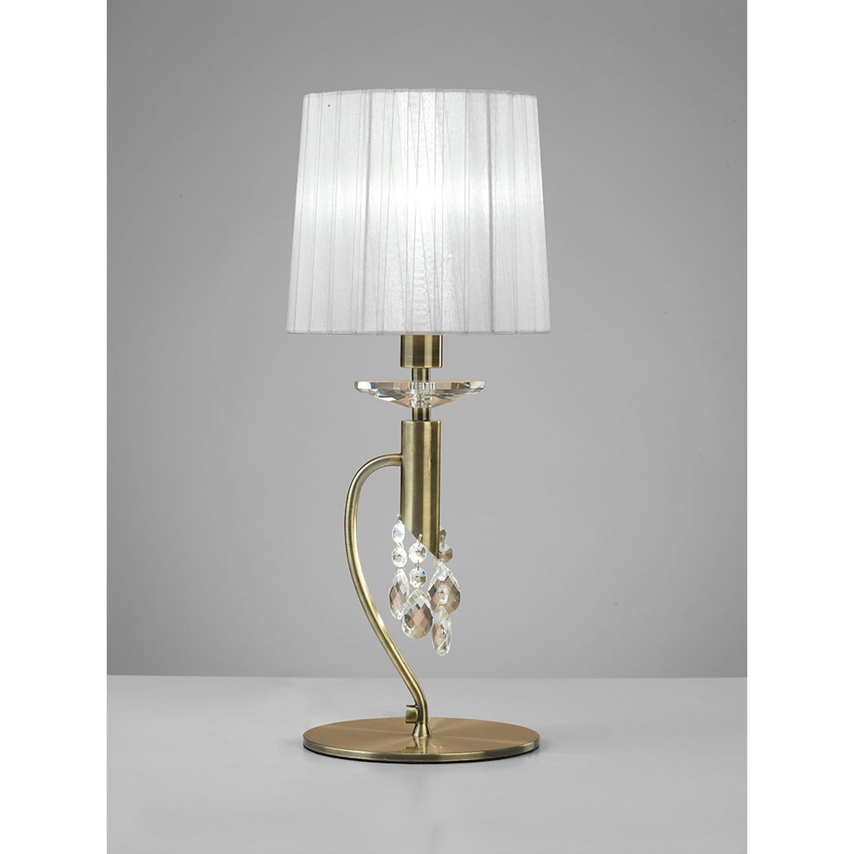 The Tiffany 2 Light Crystal Table Lamp features a brass base, crystal details, and a white shade, displayed against a plain gray background.