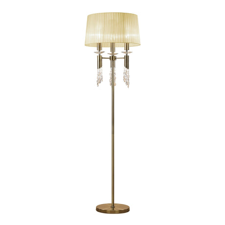 The Tiffany 6 Light Crystal Floor Lamp in brass features a round base, cream pleated shade, and hanging crystal accents for an elegant look.